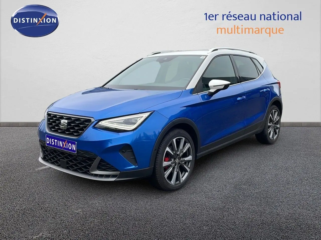 Vue 3/4 avant droite d’un SEAT Arona bleu saphir métal avec toit blanc et jantes alliage sport.