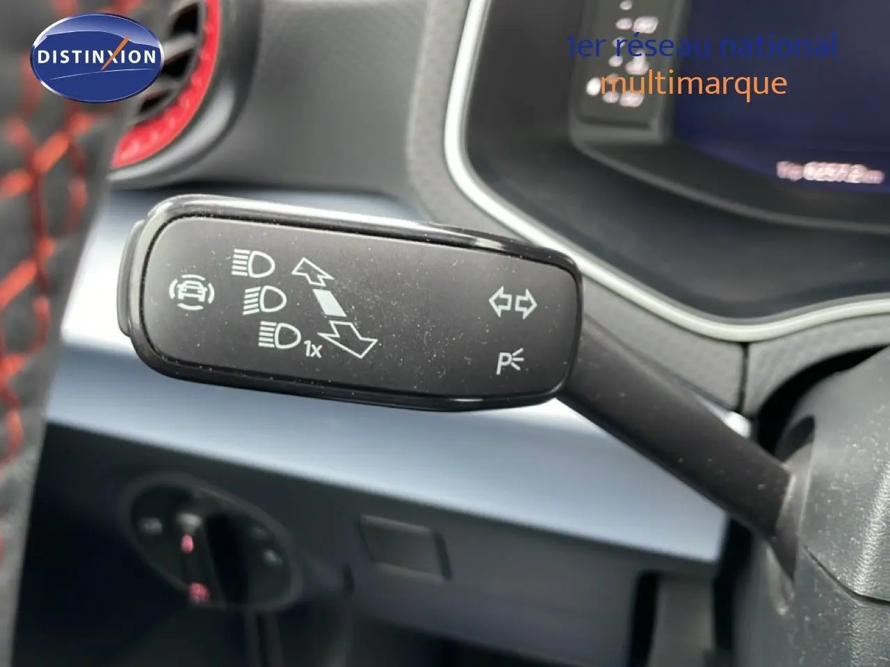 Gros plan sur la commande de clignotants dans l’habitacle d’une SEAT Arona bleu saphir métal avec toit blanc.