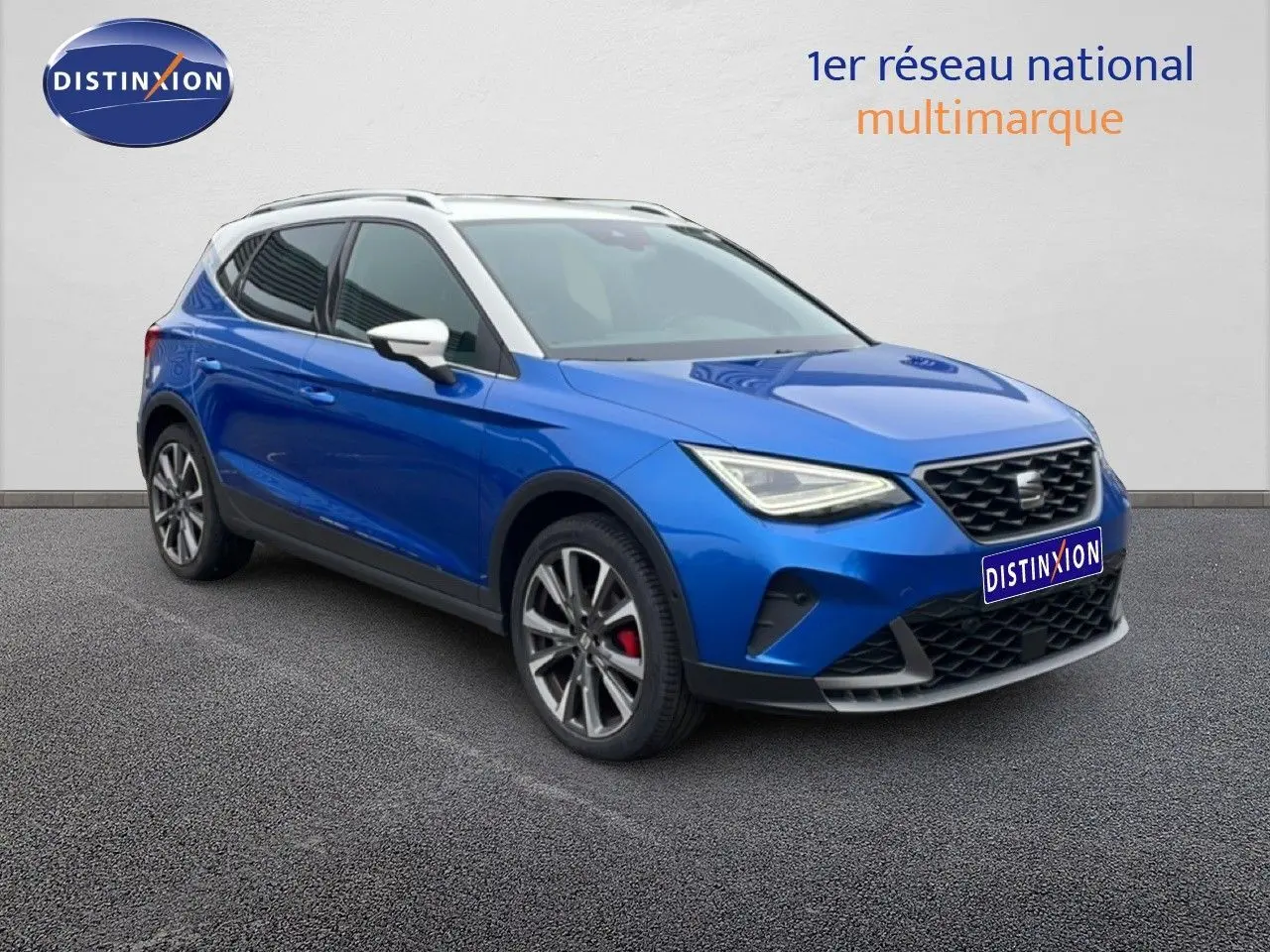 SEAT Arona 2025 bleu saphir métal avec toit blanc, vue 3/4 avant mettant en valeur les jantes et calandre.