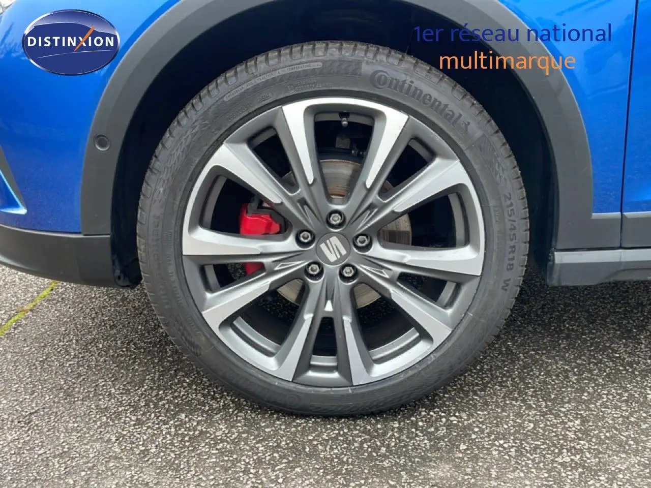 Gros plan sur la roue avant droite du SEAT Arona bleu saphir métal avec étrier de frein rouge et jante alliage.