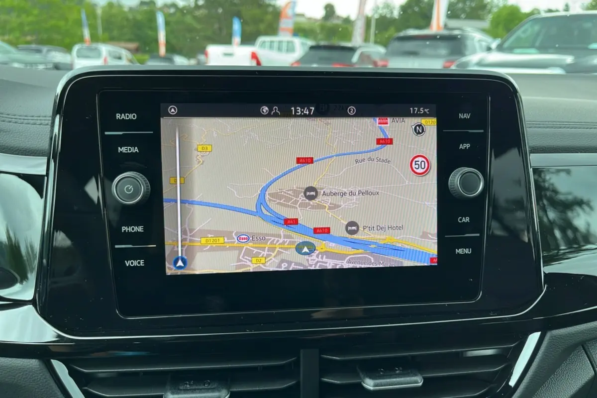 Écran tactile central du Volkswagen T-Roc 2025 affichant la navigation GPS avec commandes autour de l'écran noir brillant.