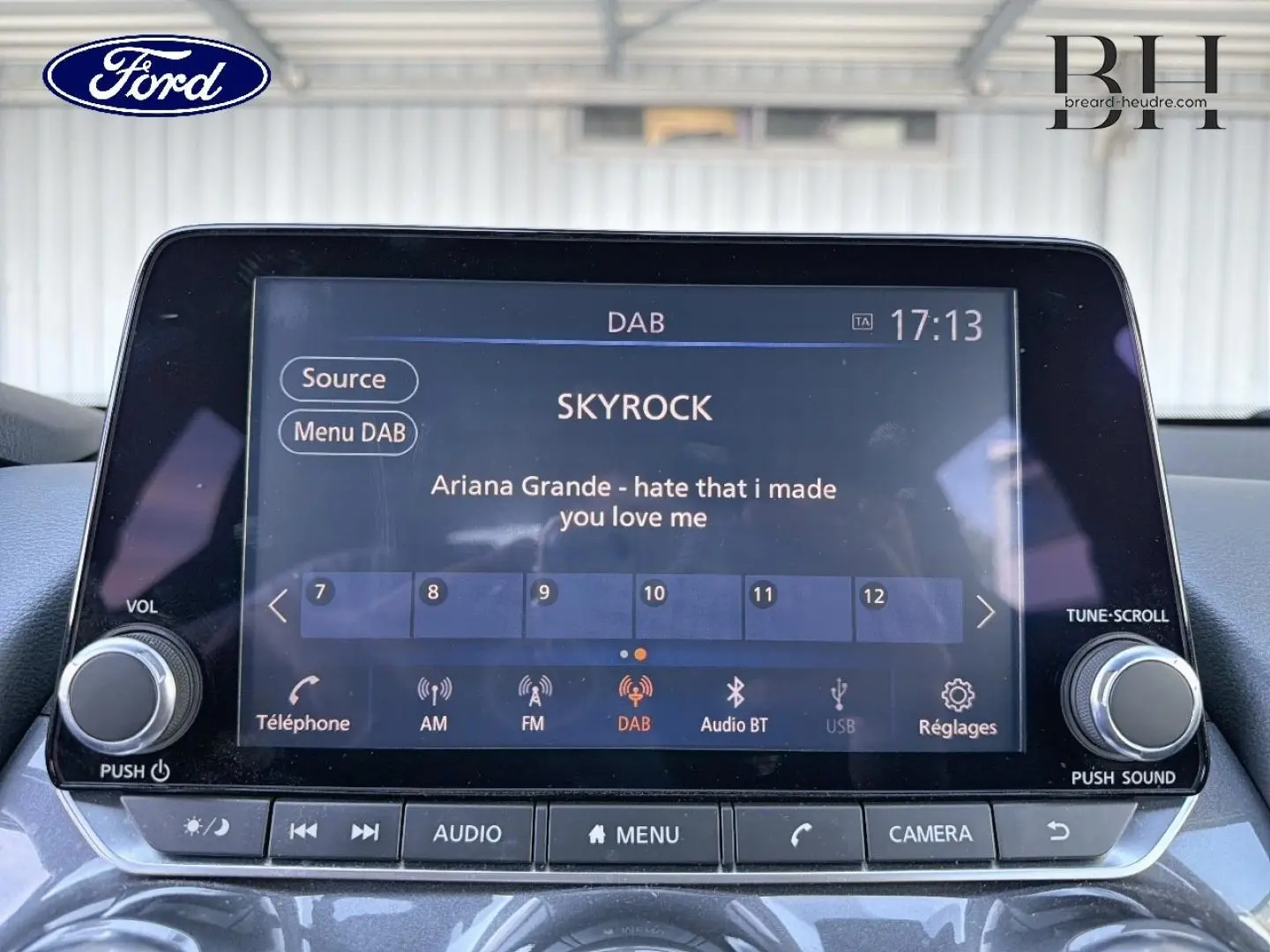 Écran tactile multimédia d'une Nissan Juke noir métallisé, affichant la radio DAB avec la station Skyrock en intérieur.