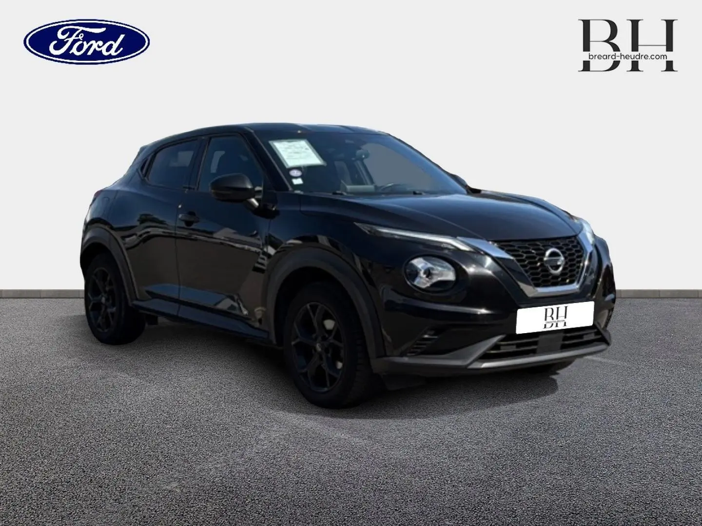 Nissan Juke noir métallisé vu en 3/4 avant droit, avec calandre distinctive et jantes noires.