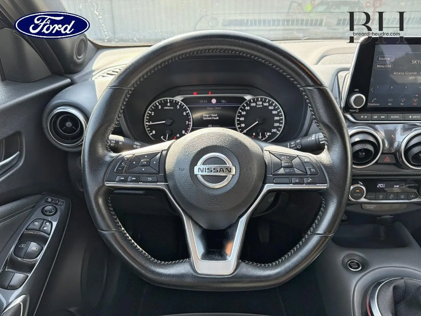 Vue intérieure centrée sur le volant cuir noir du Nissan Juke 2020 avec tableau de bord et écran tactile visibles.