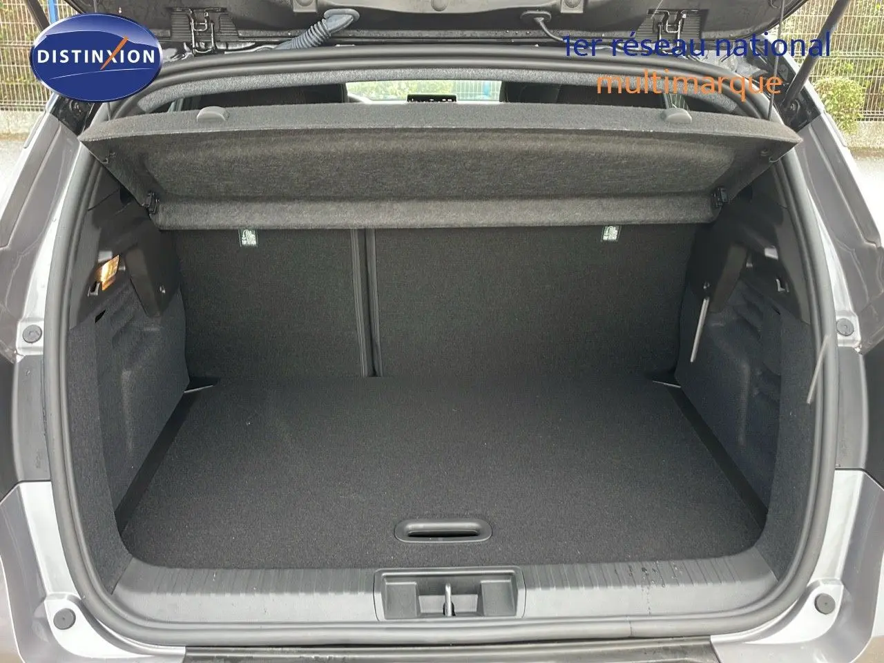 Coffre ouvert du Renault Captur gris Cassiopée métal avec toit noir, vue arrière montrant l'espace de chargement vide.