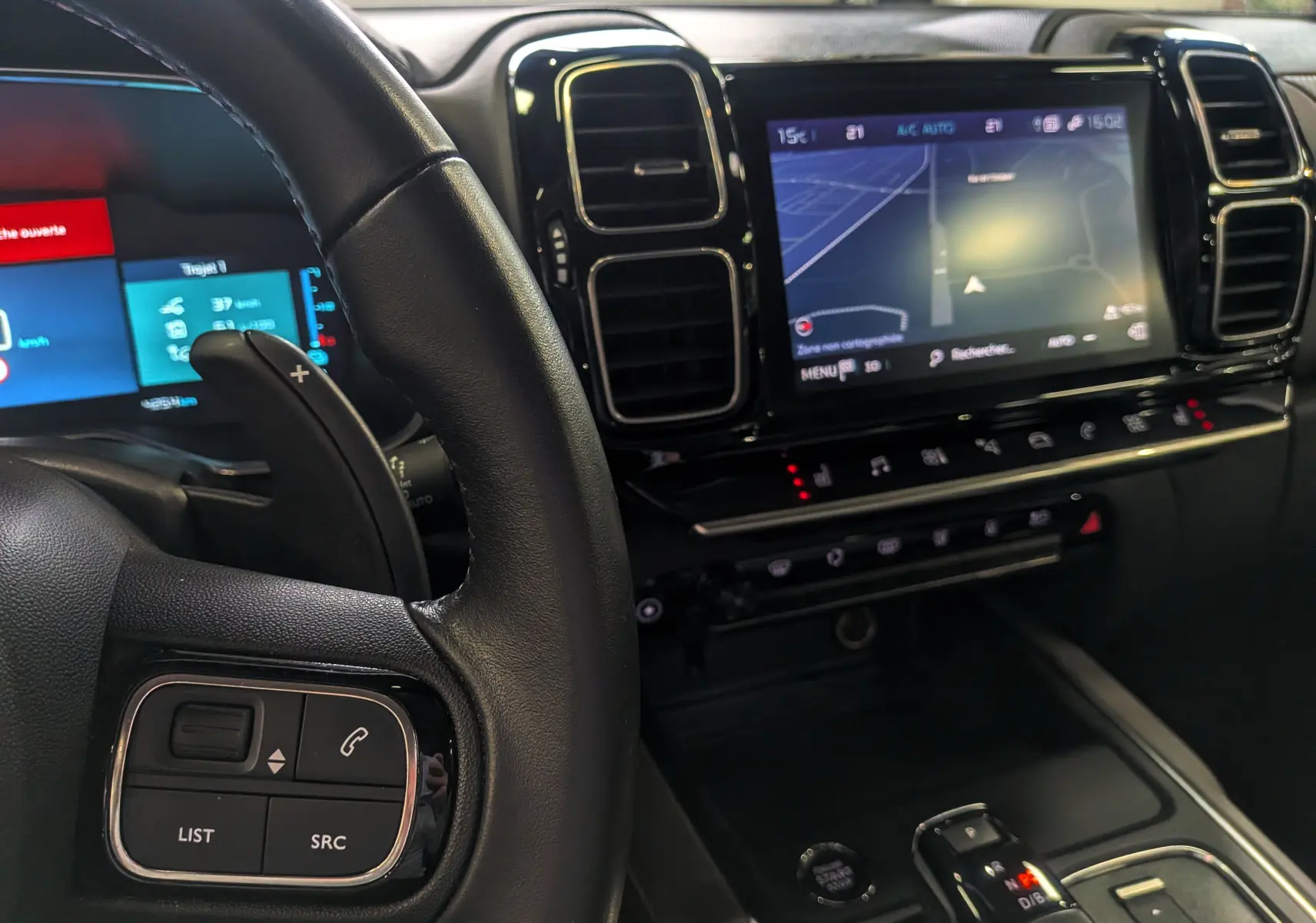 Vue rapprochée de l'intérieur du Citroën C5 Aircross hybride blanc, avec tableau de bord numérique et écran tactile central.