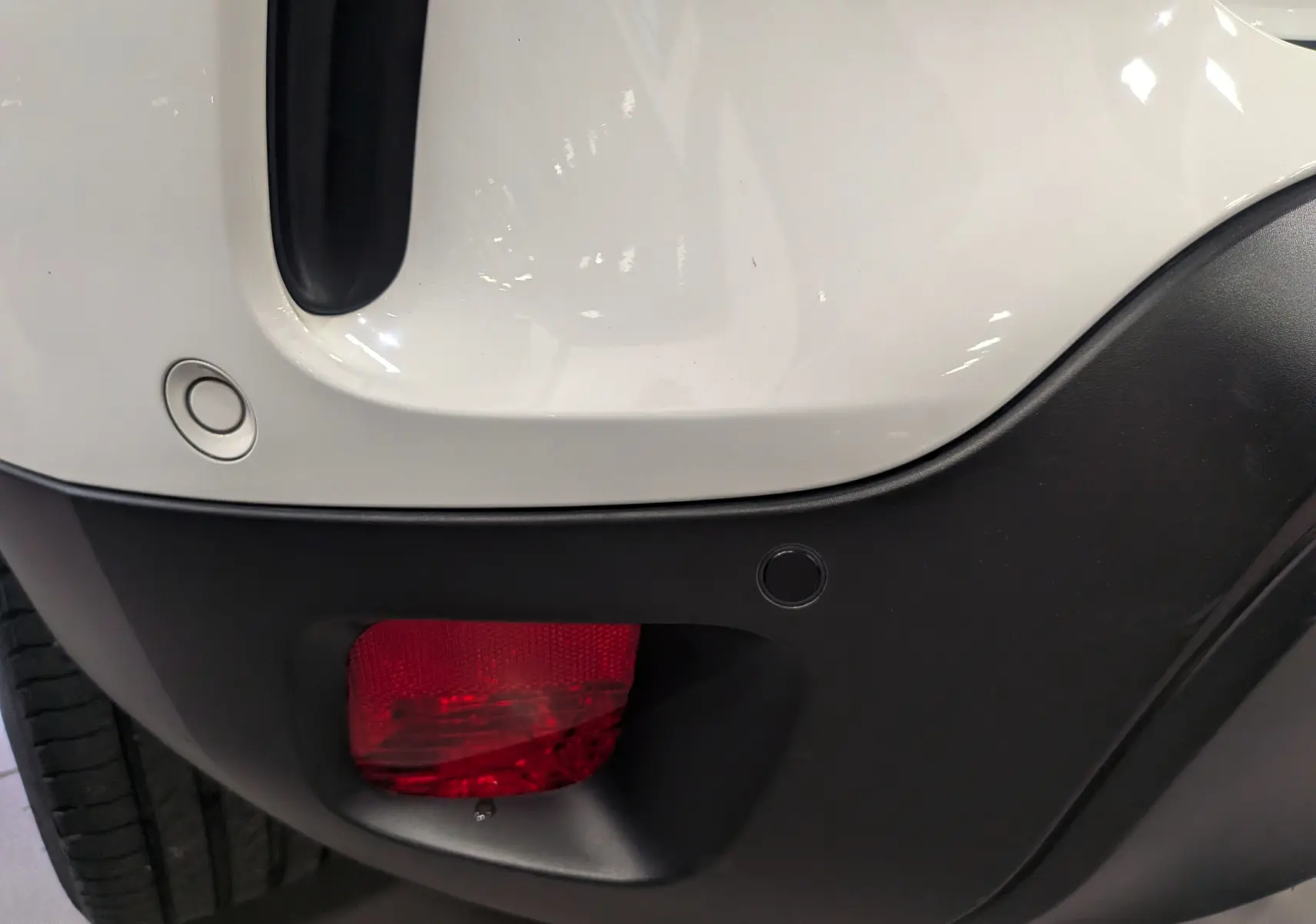 Gros plan sur le feu arrière droit rouge et le pare-chocs noir du Citroën C5 Aircross blanc glacier hybride rechargeable.
