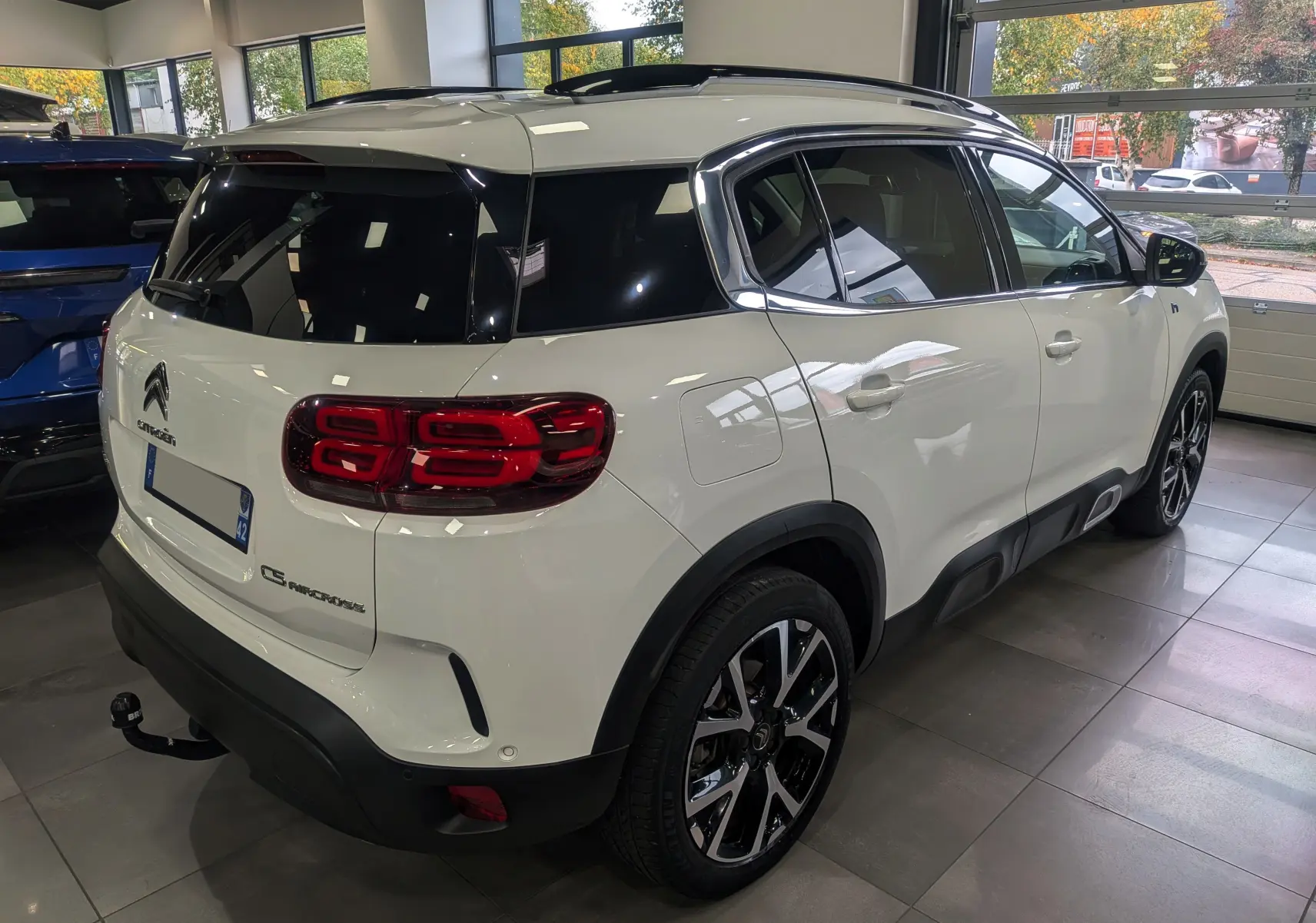 Vue 3/4 arrière droite du Citroën C5 Aircross blanc glacier avec toit noir et jantes alliage bicolores.