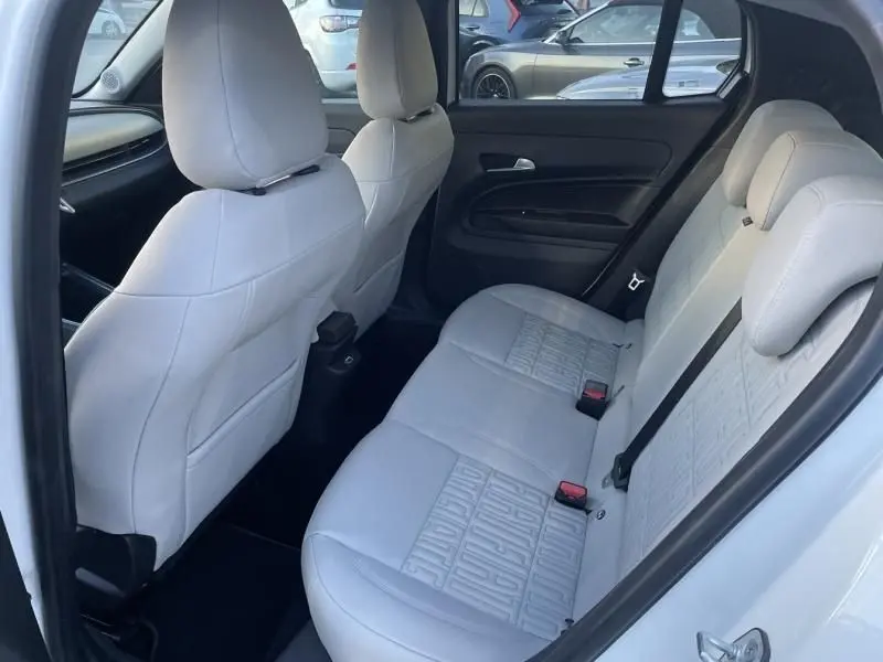 Vue intérieure arrière côté droit du Fiat 600 blanc 2025, sièges en cuir clair avec motifs embossés distinctifs.