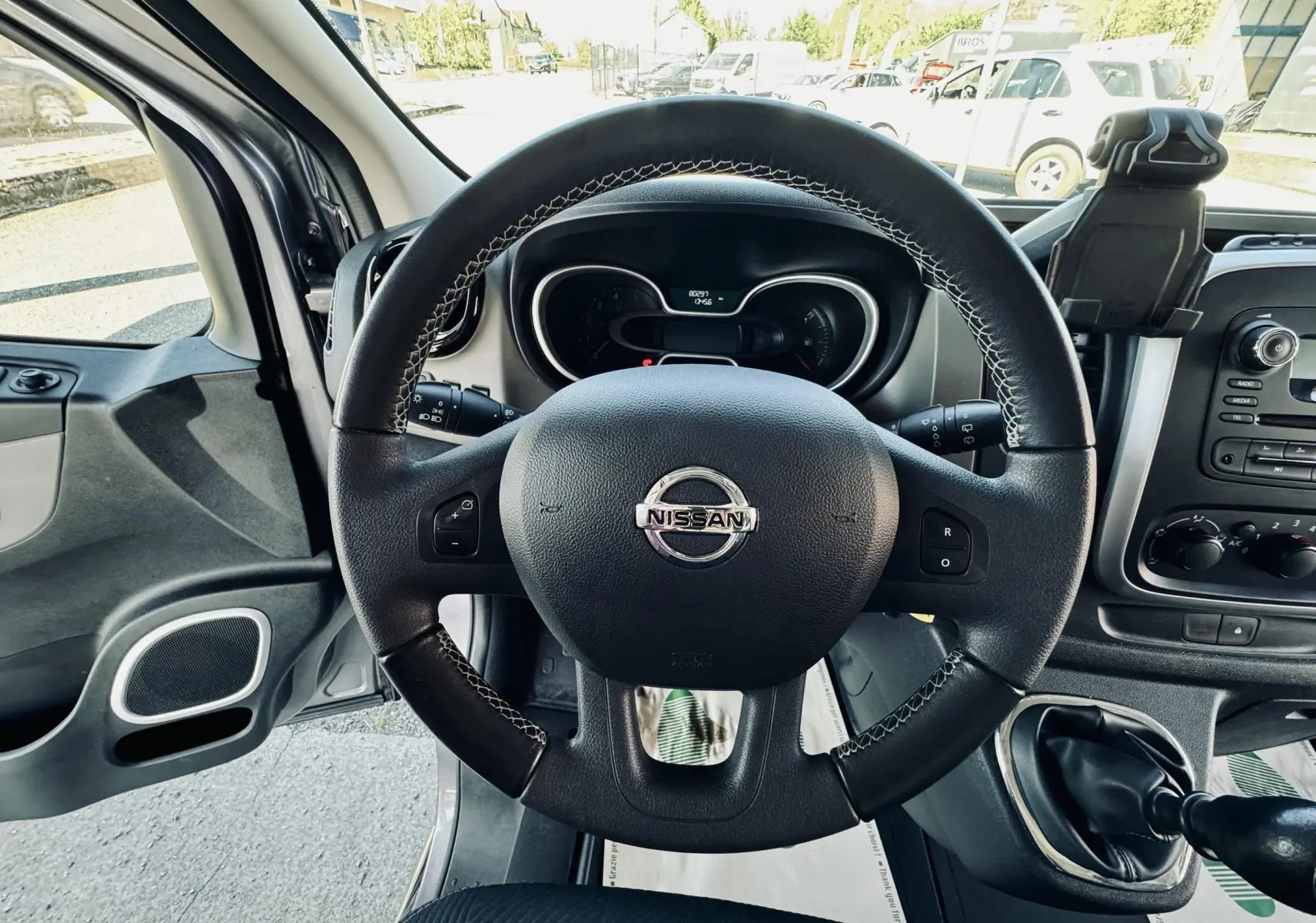 Vue intérieure centrée sur le volant noir du Nissan NV300 Combi 2018 avec tableau de bord et levier de vitesses manuelle.