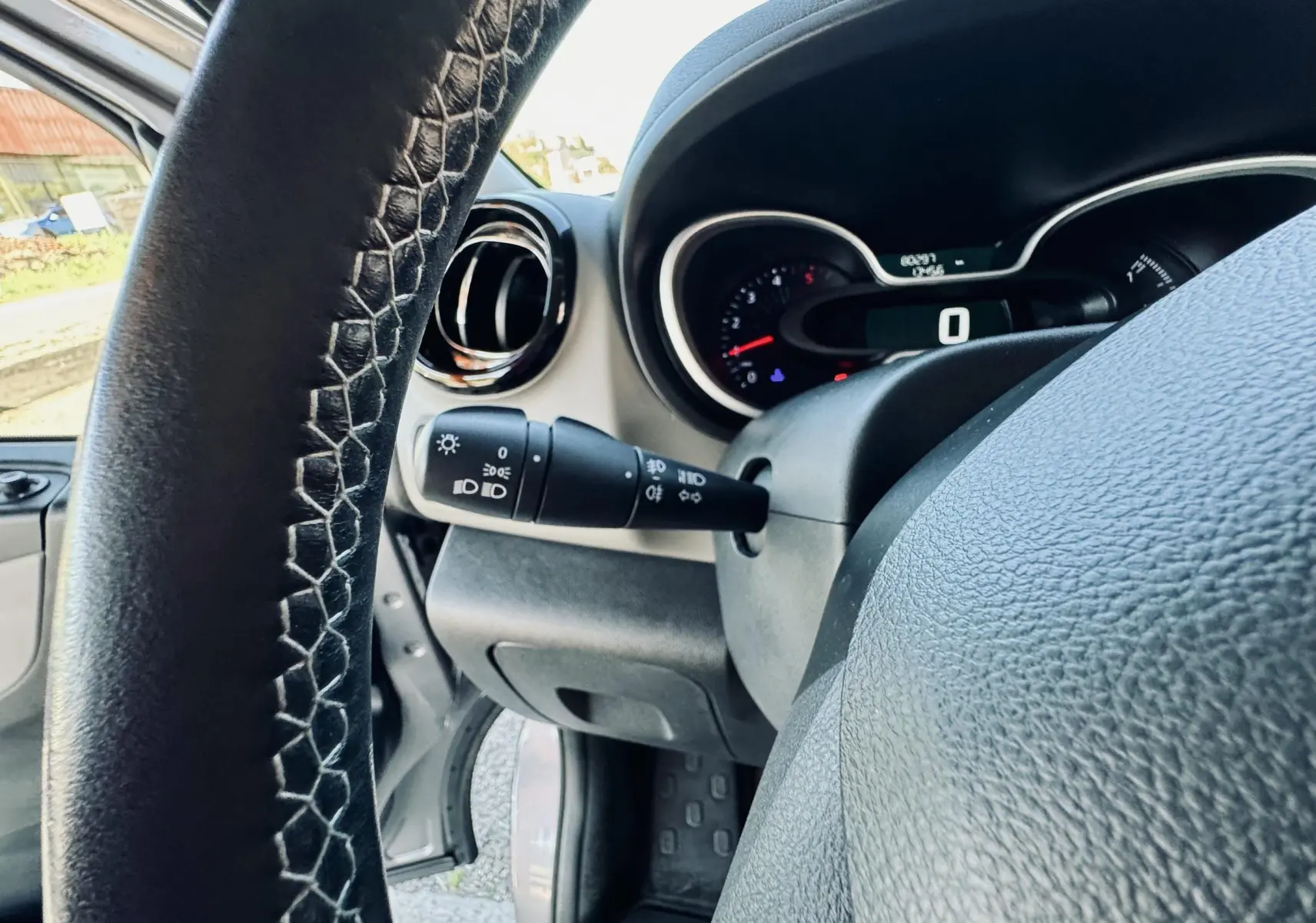 Vue rapprochée du volant et du tableau de bord gris du Nissan NV300 Combi, avec levier de clignotant visible à gauche.