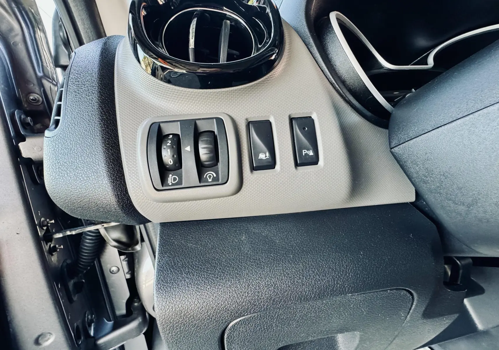 Détail des commandes côté gauche du tableau de bord gris et noir du Nissan NV300 Combi 2018.