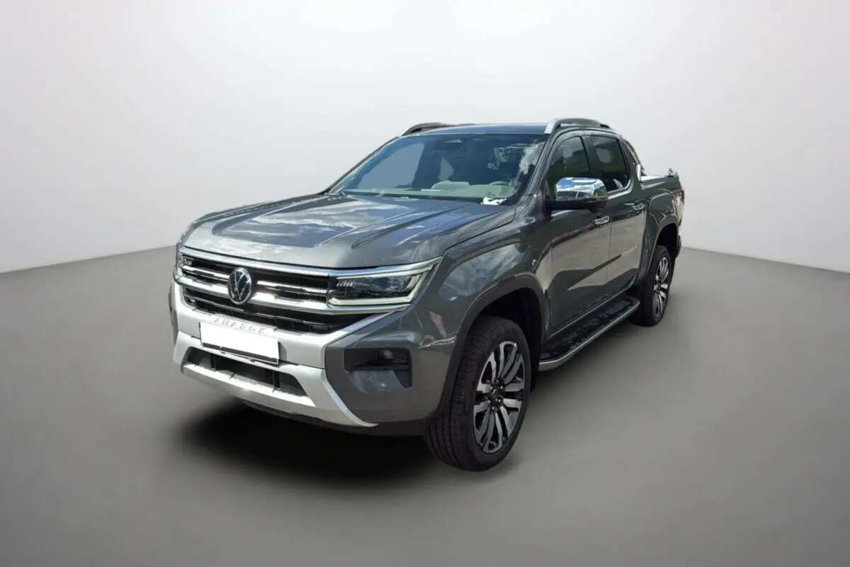 Volkswagen Amarok V6 240 BVA10 Aventura gris foncé, vue 3/4 avant droit avec jantes alu et barres de toit.