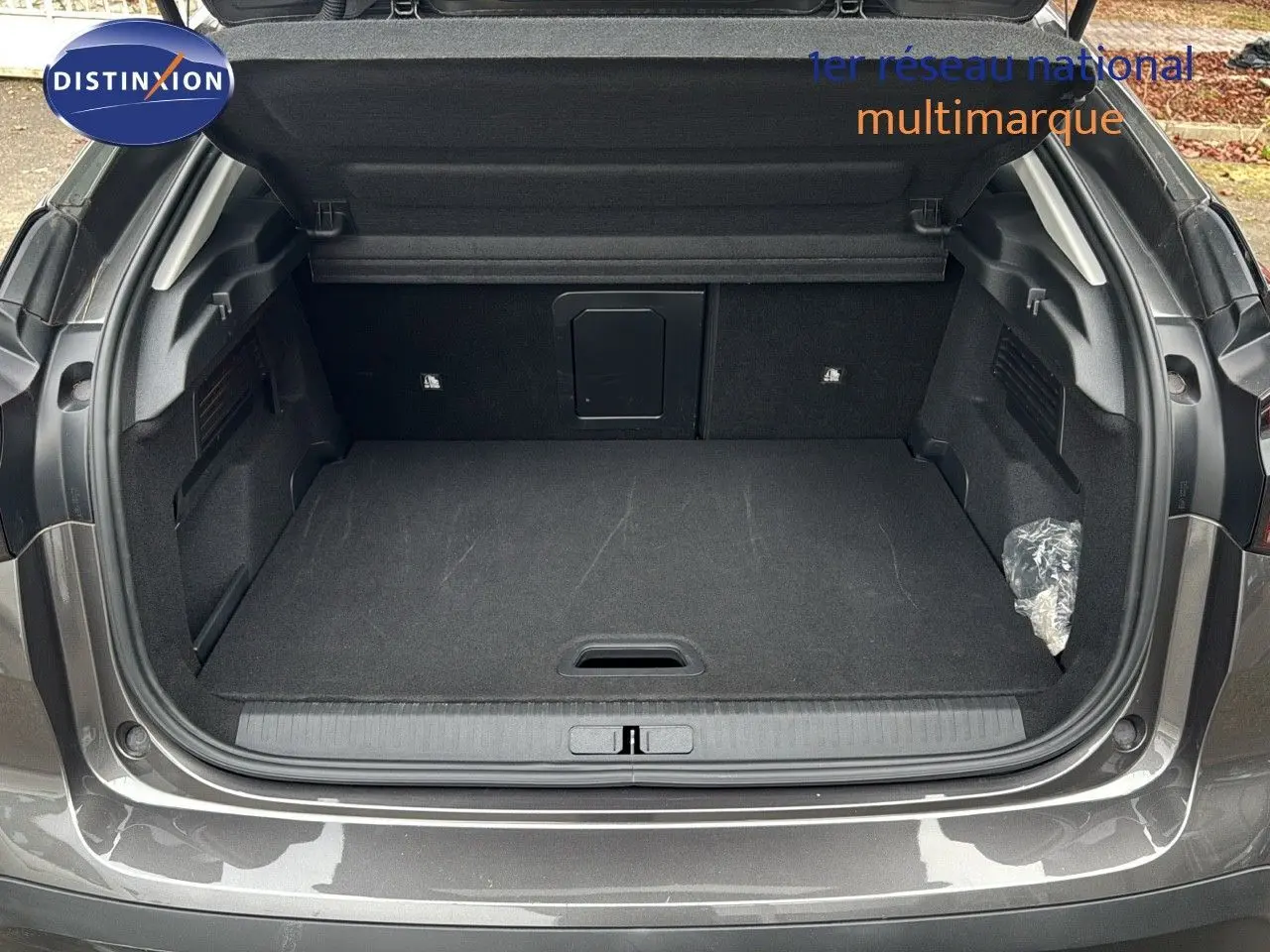 Coffre ouvert d'une Citroën C4 2021 gris avec toit noir, montrant un espace de chargement propre et spacieux.