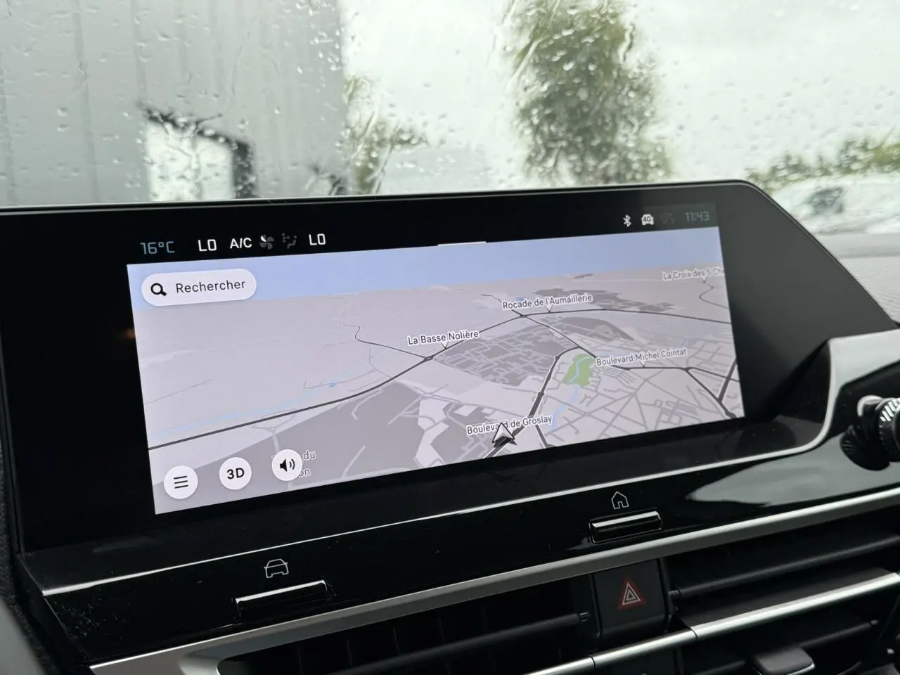 Écran tactile central affichant la navigation 3D dans l'habitacle d'une Citroën C4 hybride blanche, vue intérieure rapprochée.