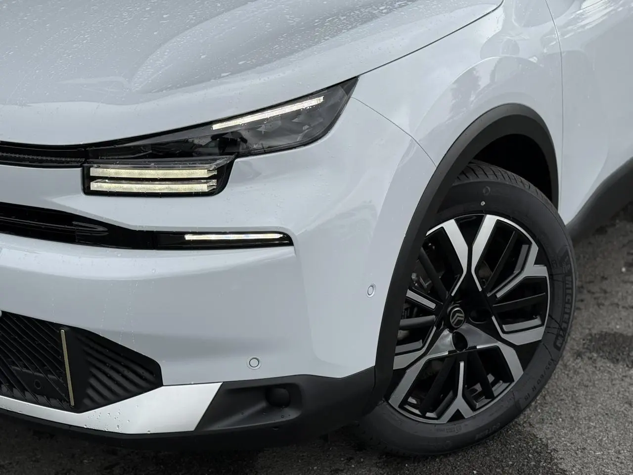 Gros plan sur l'avant droit du Citroën C4 blanc Okénite avec phares LED et jante alliage 18 pouces diamantée.