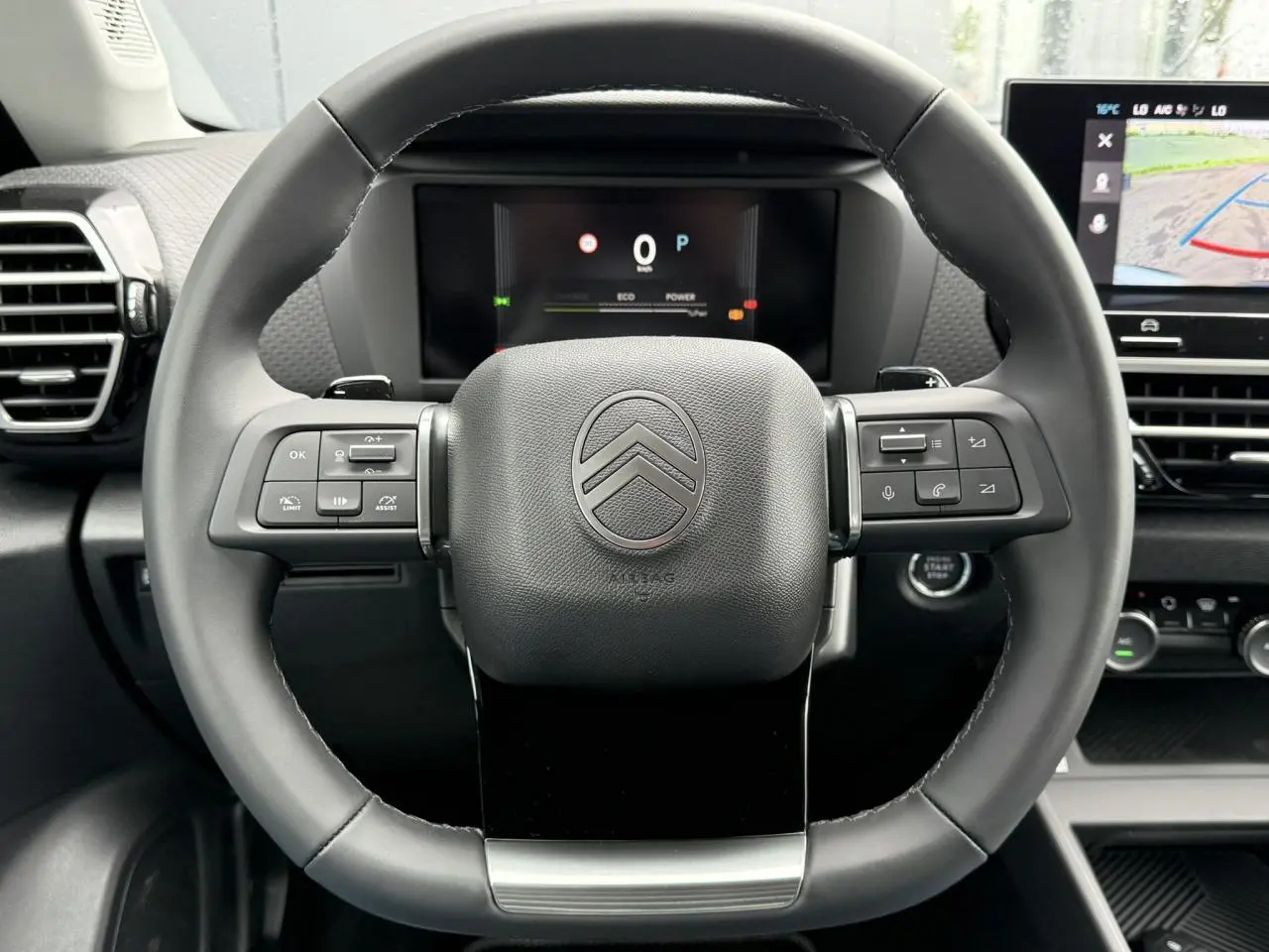 Volant cuir noir de Citroën C4 NV Hybrid 145 e-DSC6 Max vu de face avec commandes intégrées et tableau de bord numérique.