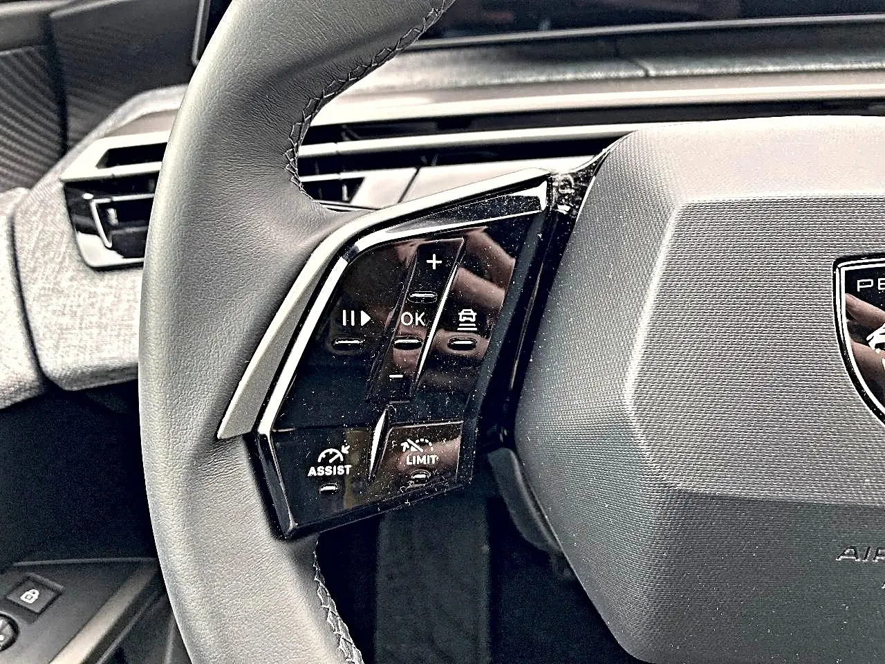 Gros plan sur le volant cuir multifonction noir du Peugeot 3008 2025 avec commandes de régulateur et assistant de conduite.