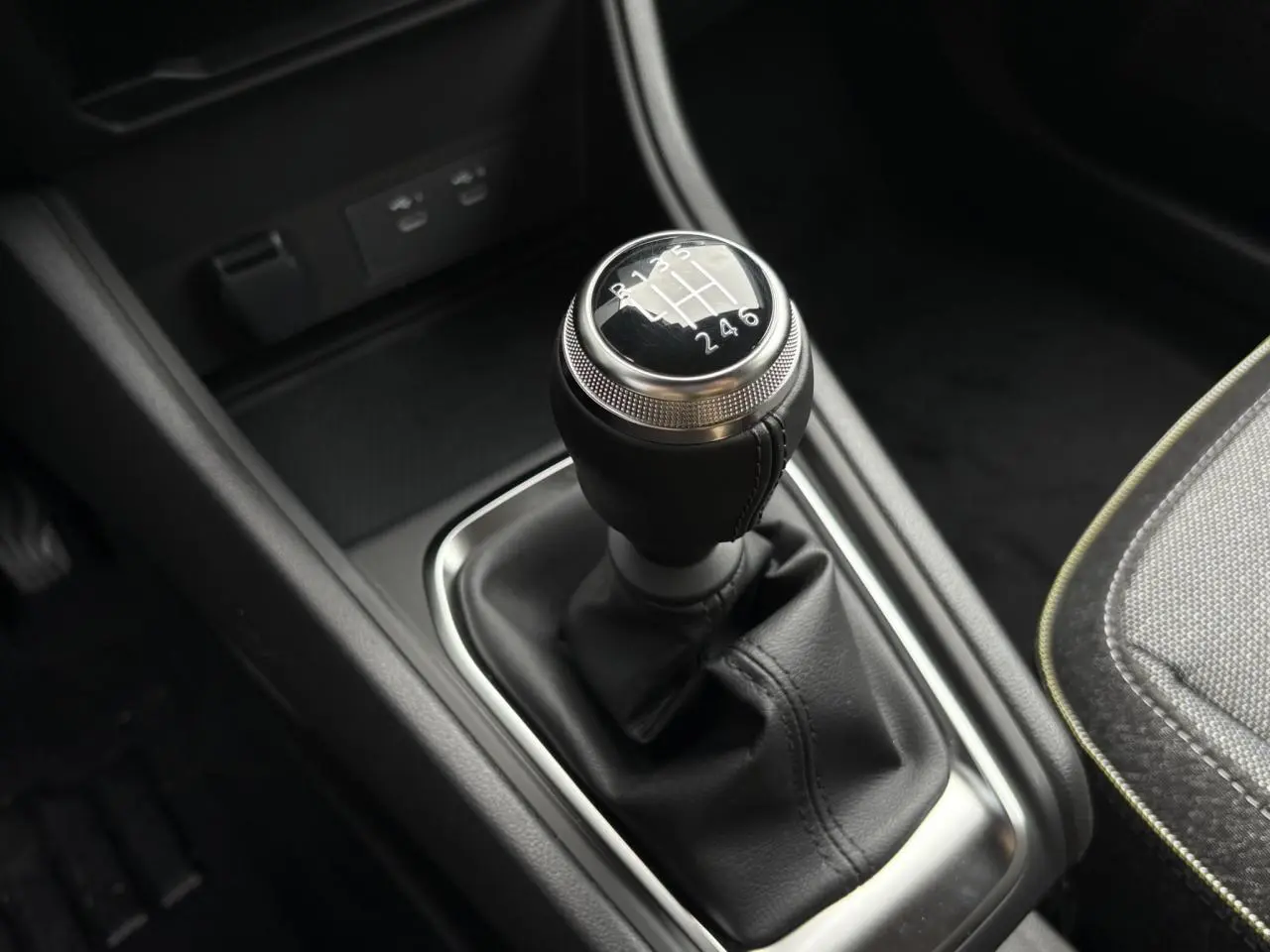 Le levier de vitesses manuel noir du Renault Captur 2025 avec coutures apparentes et console sombre.