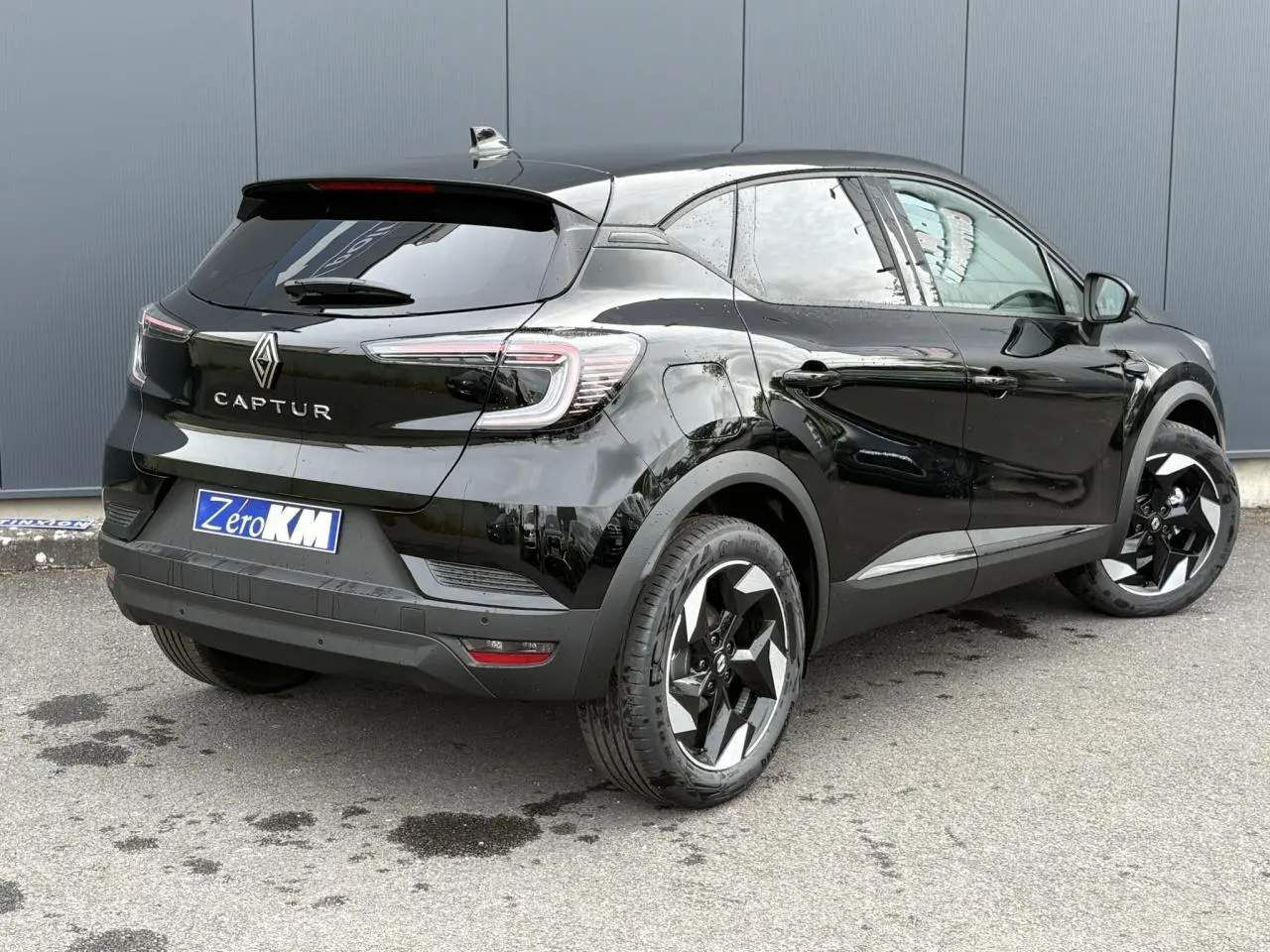 Vue 3/4 arrière droite du Renault Captur noir étoilé avec jantes aluminium 18 pouces Black Hole et vitres surteintées.