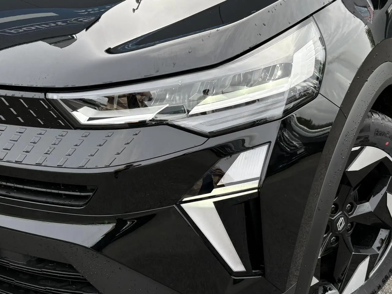 Gros plan sur l'avant droit noir étoilé du Renault Captur 2025 avec phares LED et jante aluminium 18 pouces Black Hole.