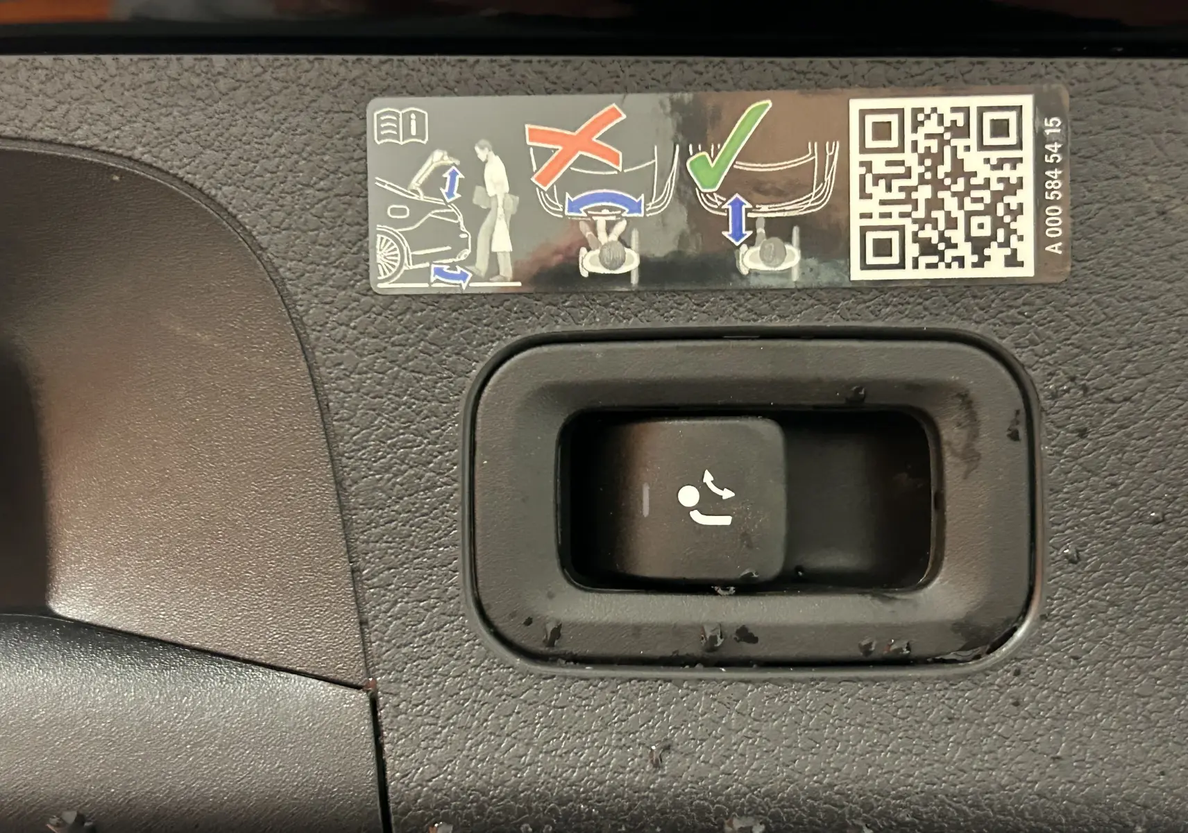 Gros plan sur la commande de rabattement des sièges arrière dans une Mercedes CLA Shooting Brake noir métallisé 2024