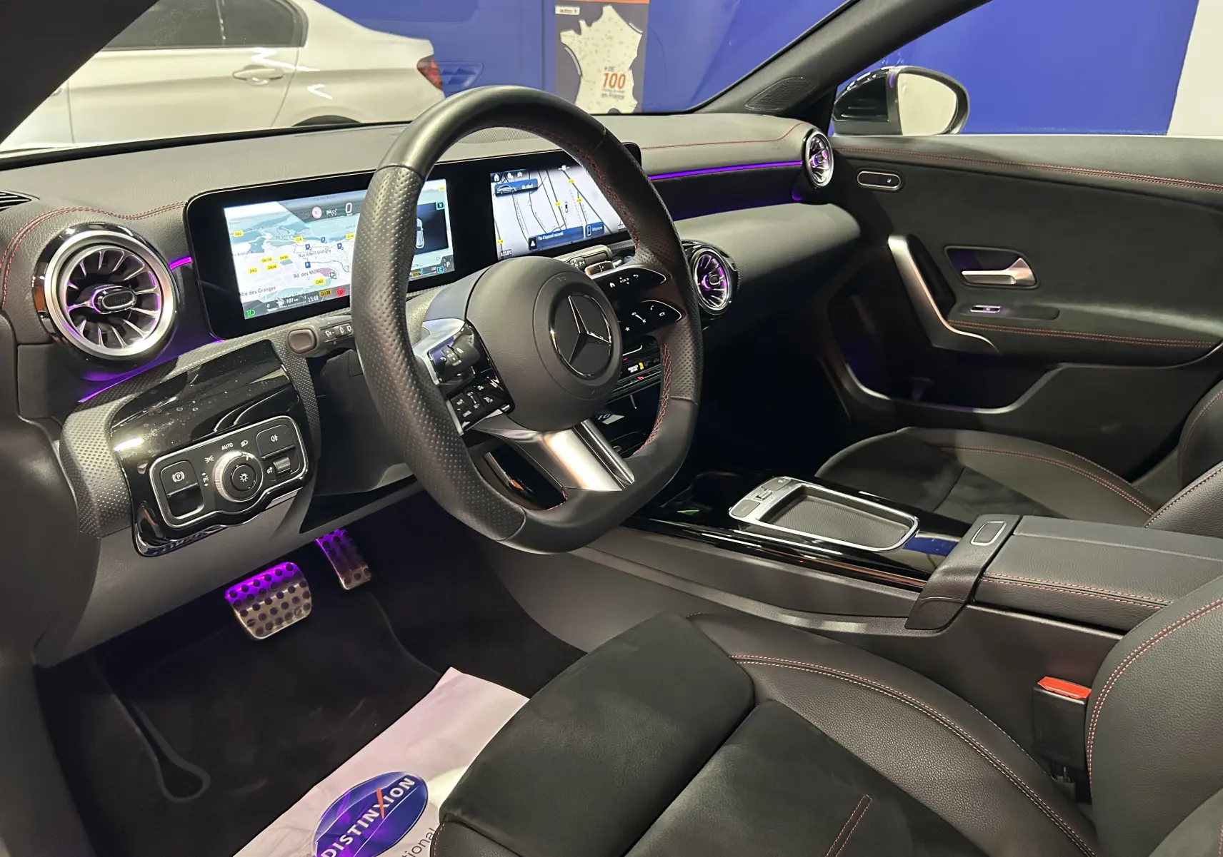 Intérieur noir avec surpiqûres rouges de la Mercedes CLA Shooting Brake II 200D AMG, vue côté conducteur, tableau de bord digital.