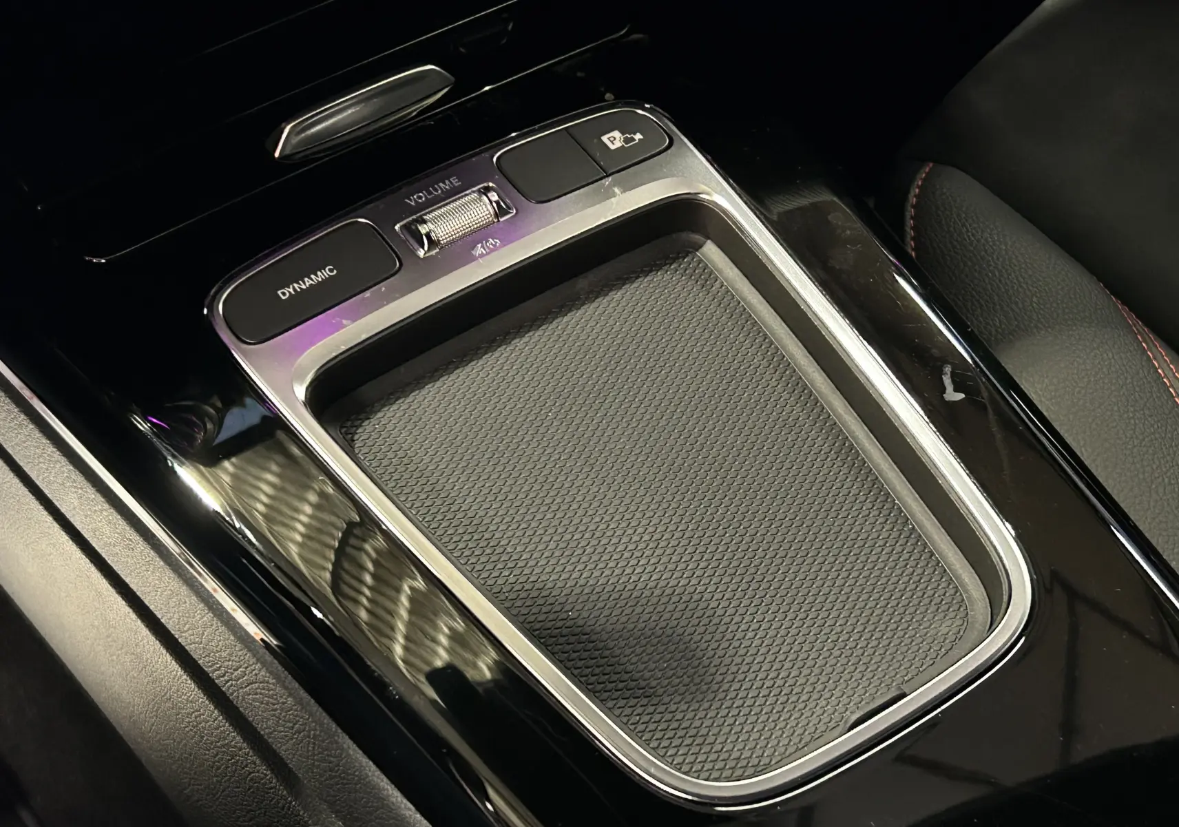 Gros plan sur la console centrale noire brillante de la Mercedes Classe CLA Shooting Brake II 200D AMG avec commandes Dynamic et volume.