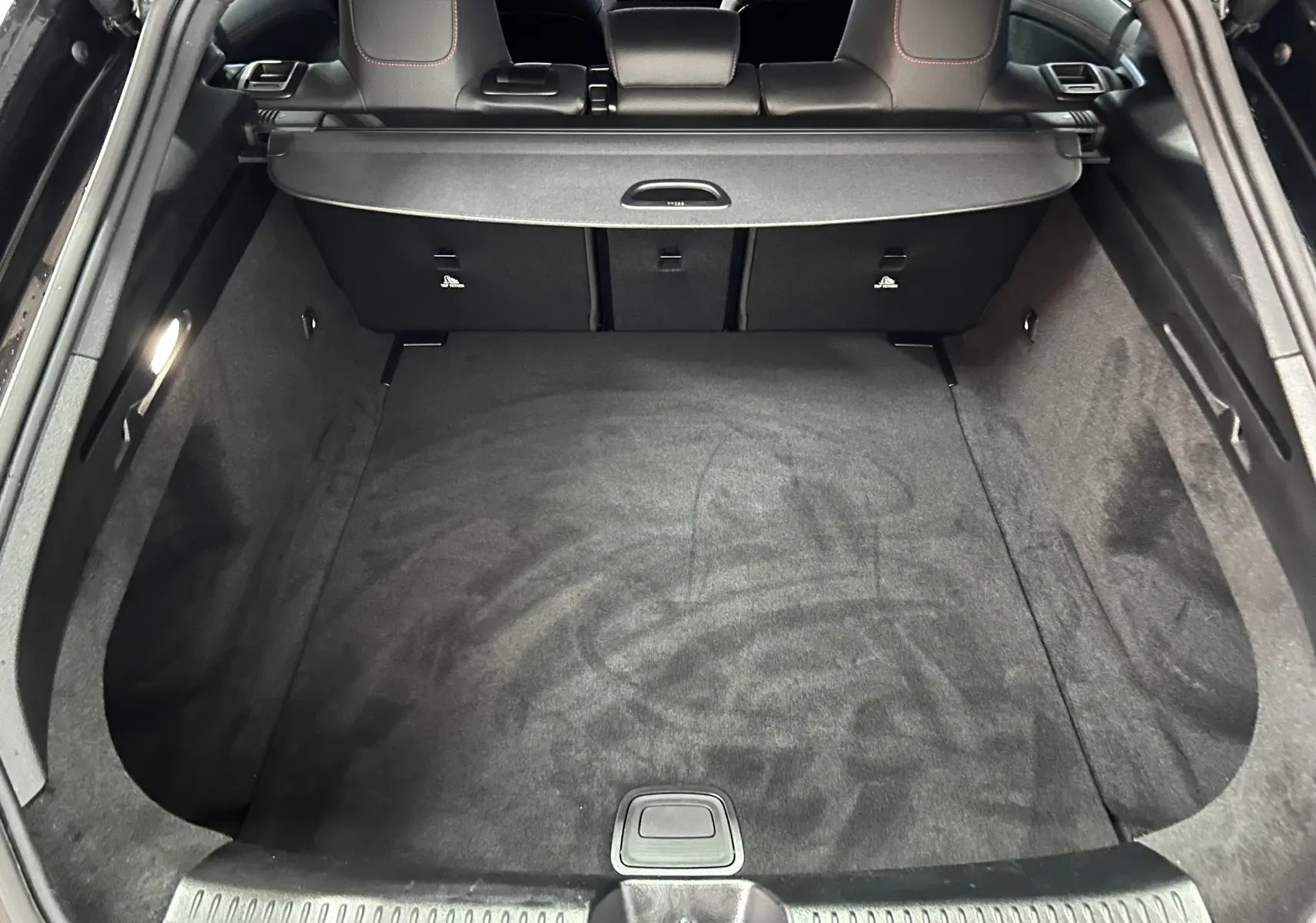 Coffre spacieux et propre de la Mercedes Classe CLA Shooting Brake II 200D AMG noir métallisé vu de l'arrière ouvert.