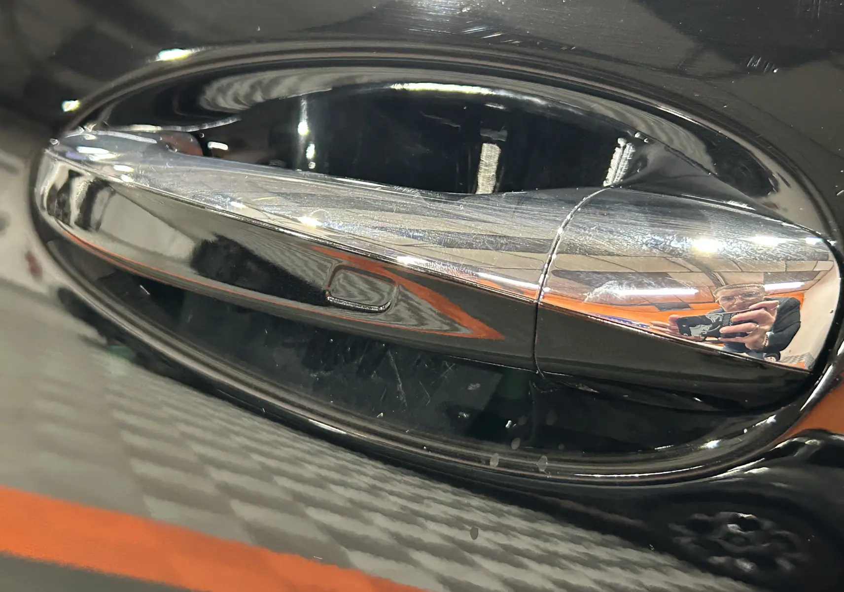 Poignée de porte chromée en gros plan sur le côté gauche d'une Mercedes CLA Shooting Brake noire métallisée.