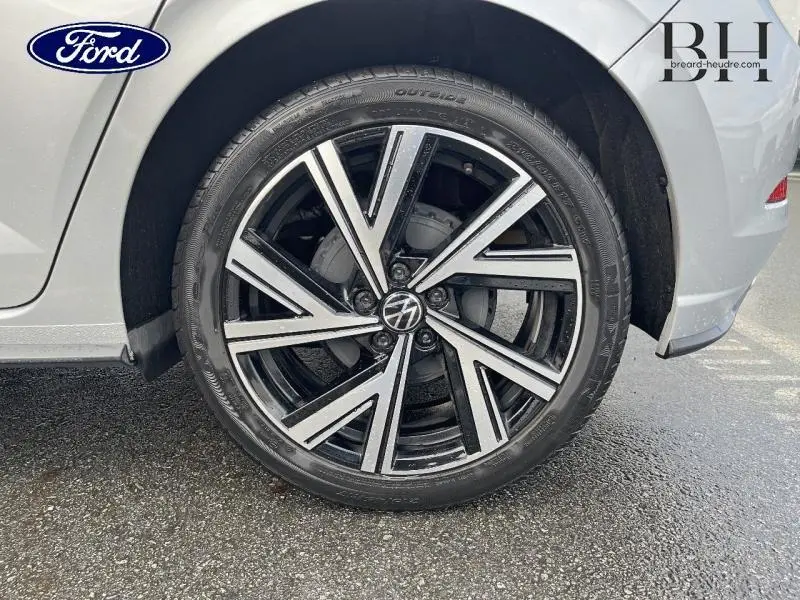 Gros plan sur la roue avant droite d'une Volkswagen Polo 2022 en Reflet d'Argent métallisé avec jante alu noire et argentée.