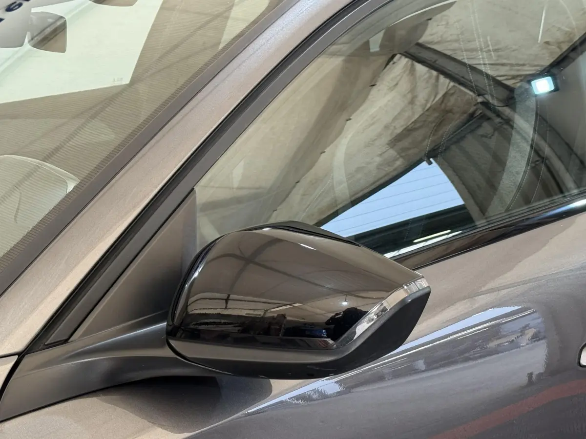 Rétroviseur côté conducteur noir brillant sur Peugeot 308 gris foncé, vue rapprochée du côté gauche.