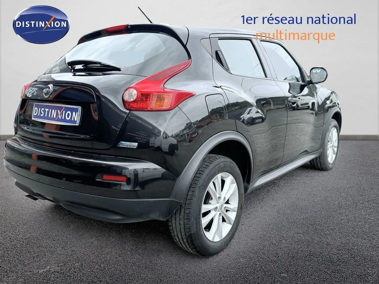 Vue 3/4 arrière droite d'un Nissan Juke noir de 2012 avec feux arrière distinctifs et jantes blanches.