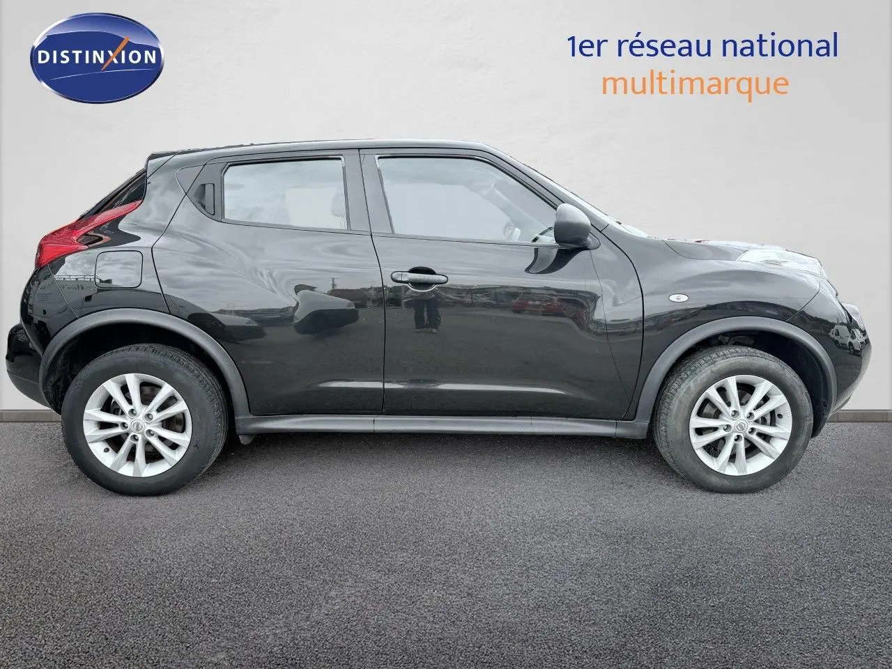 Profil latéral droit d'un Nissan Juke noir 2012 avec jantes alliage et poignées de porte intégrées.
