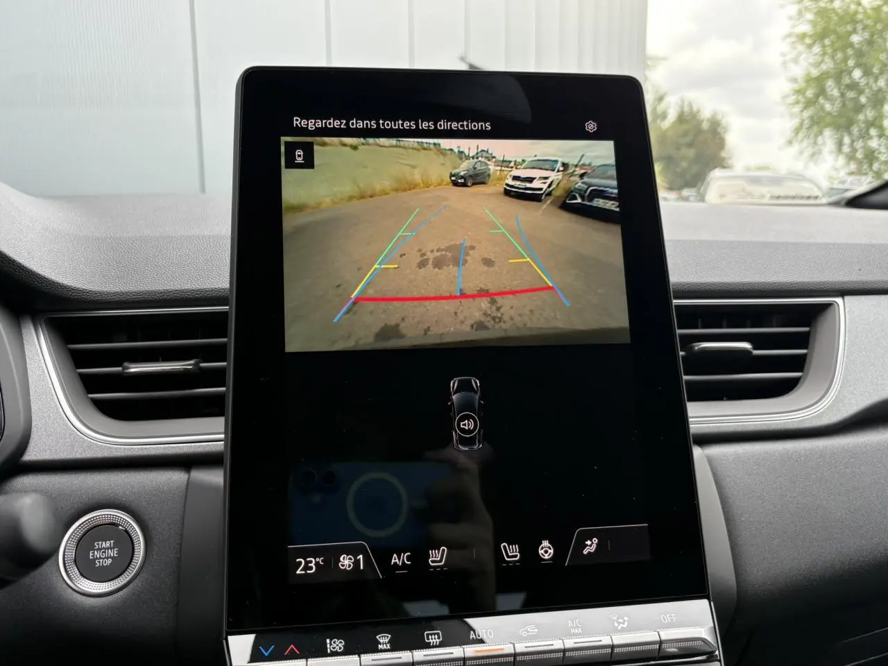 Écran central tactile du Renault Captur noir étoile 2025 montrant la caméra de recul avec lignes de guidage colorées.