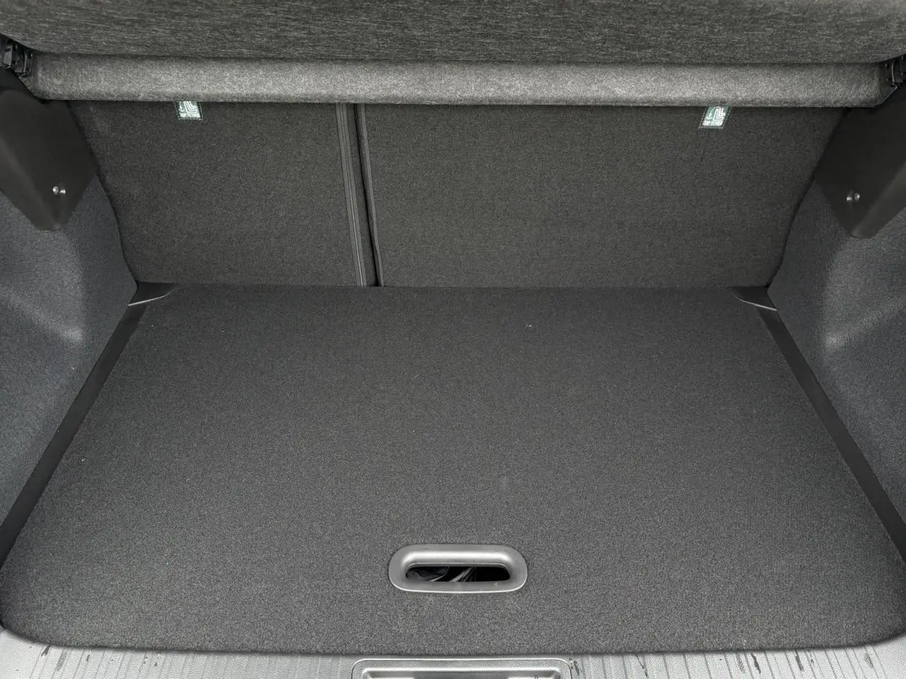 Coffre spacieux et vide du Renault Captur Noir Étoile 2025 vu de l'arrière, avec plancher plat et revêtement sombre.