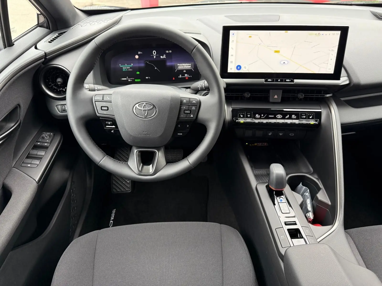 Vue intérieure du poste de conduite du Toyota C-HR 1.8 140CH STYLE MY25 avec écran tactile et volant multifonction.