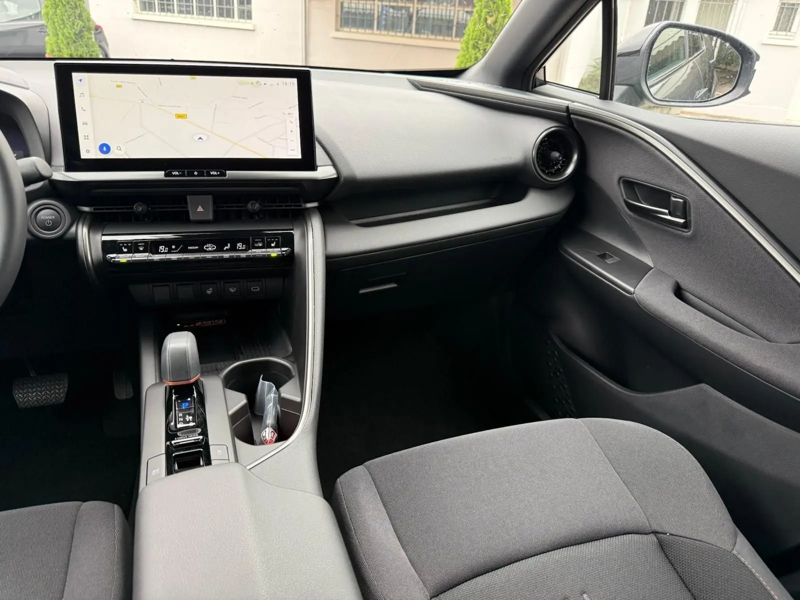 Intérieur du Toyota C-HR 1.8 140CH STYLE 2025, vue côté passager avec écran tactile et console centrale moderne.