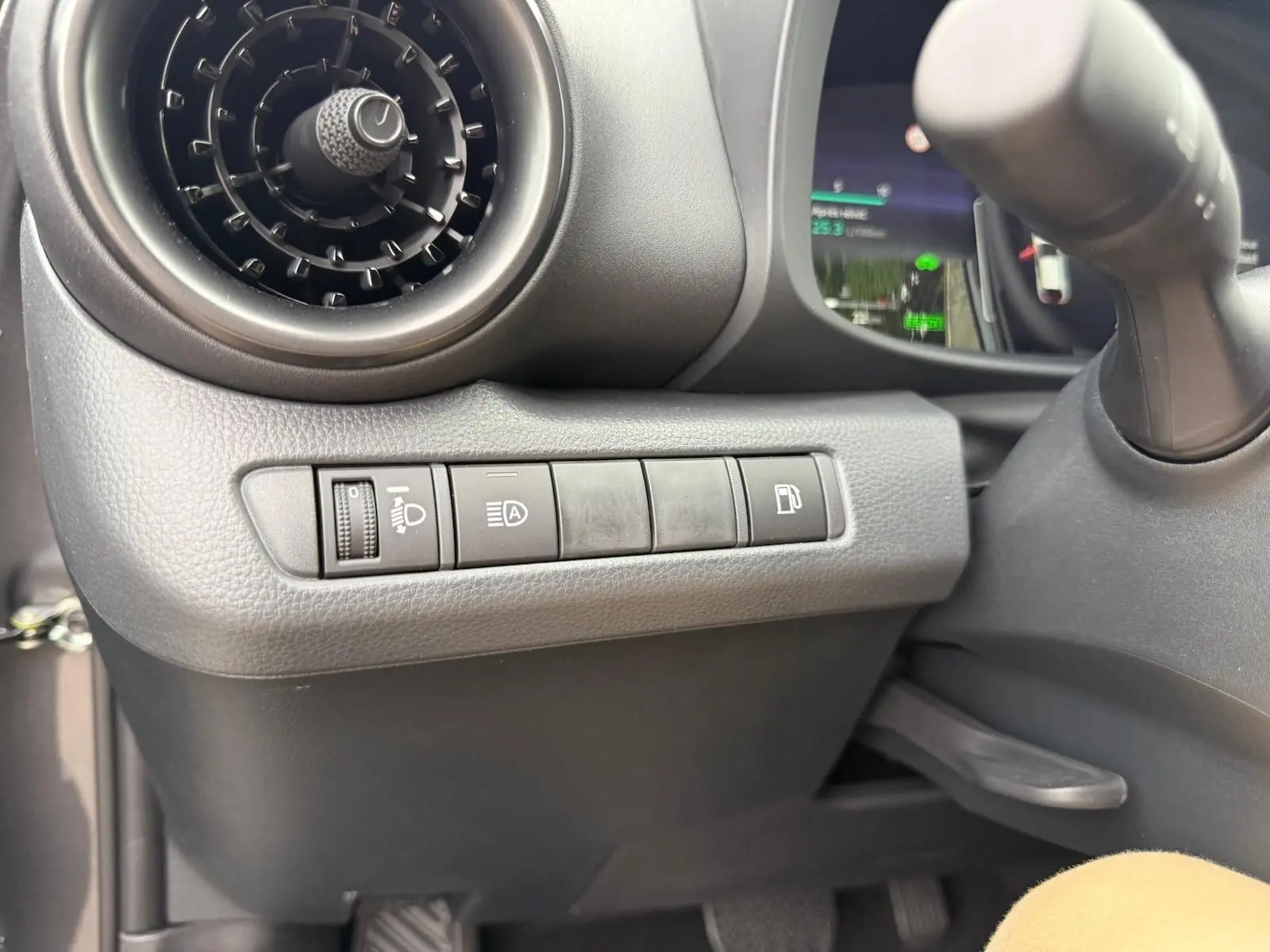 Détail du tableau de bord côté gauche du Toyota C-HR gris atlas 2025, montrant les commandes d'éclairage et de carburant.