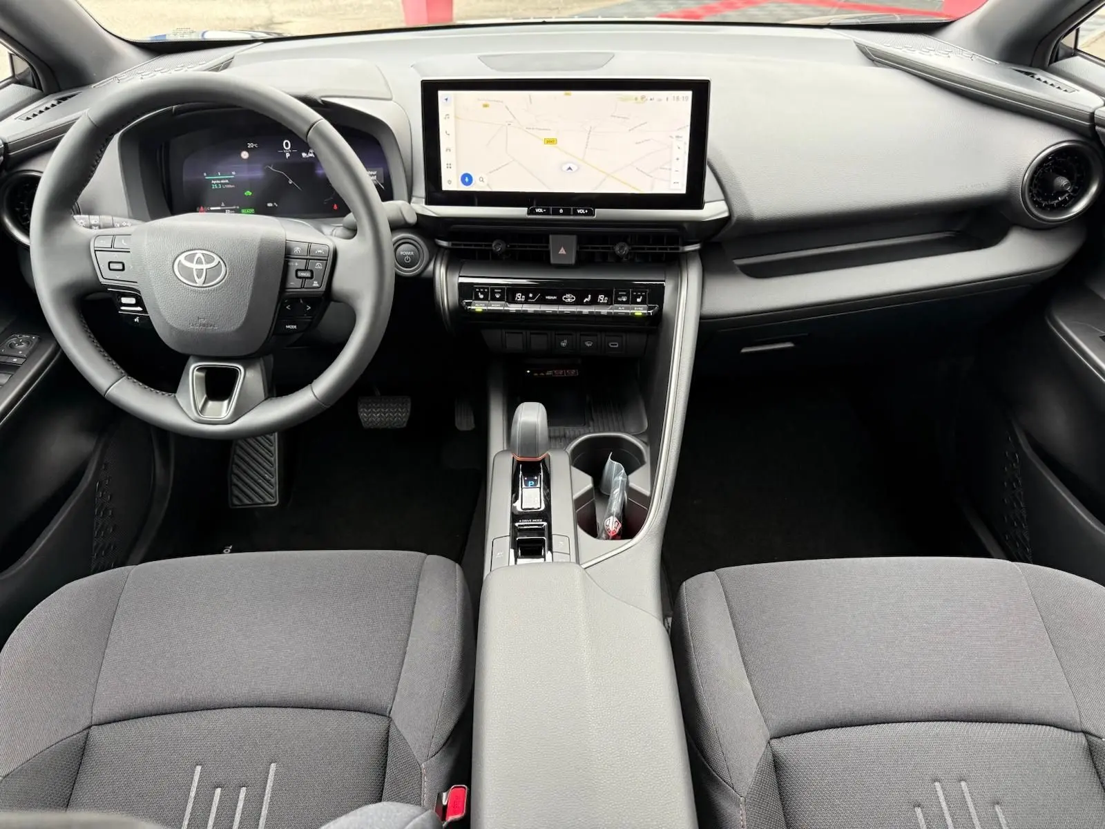 Intérieur du Toyota C-HR 1.8 140CH STYLE MY25, vue avant centrée sur le tableau de bord et écran tactile GPS.
