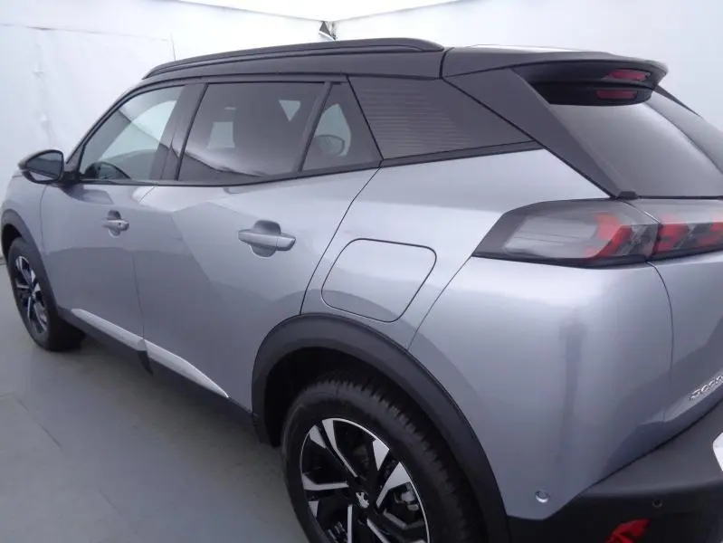 Vue 3/4 arrière droite du Peugeot 2008 gris Artense avec toit noir et jantes alliage distinctives.