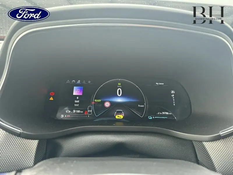 Tableau de bord numérique de Renault Arkana 1.6 E-Tech 145ch Intens 2022 affichant vitesse et alertes, vue de face intérieure.