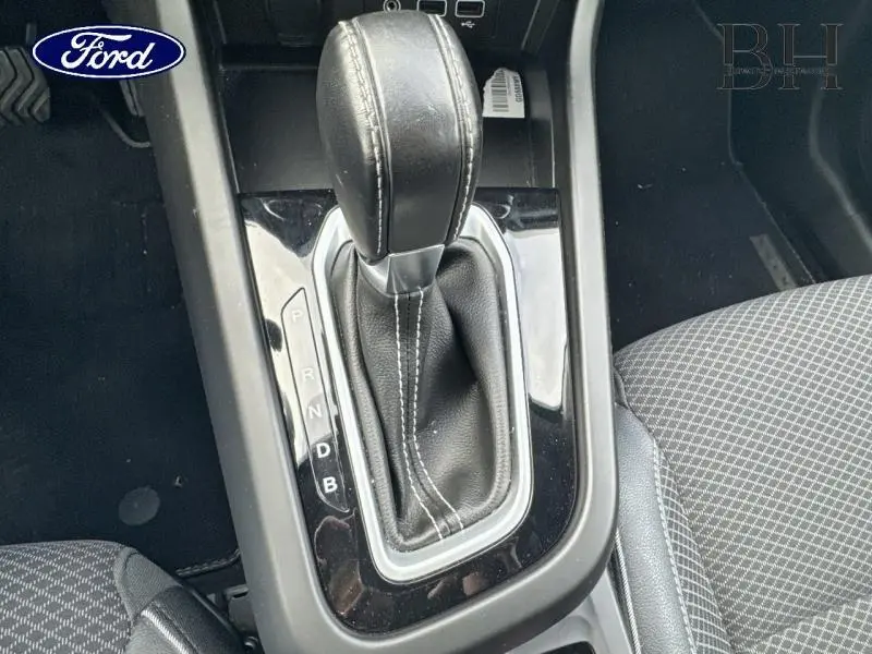 Levier de vitesse automatique en cuir noir vu de dessus dans l'habitacle d'une Renault Arkana bleu Zanzibar.