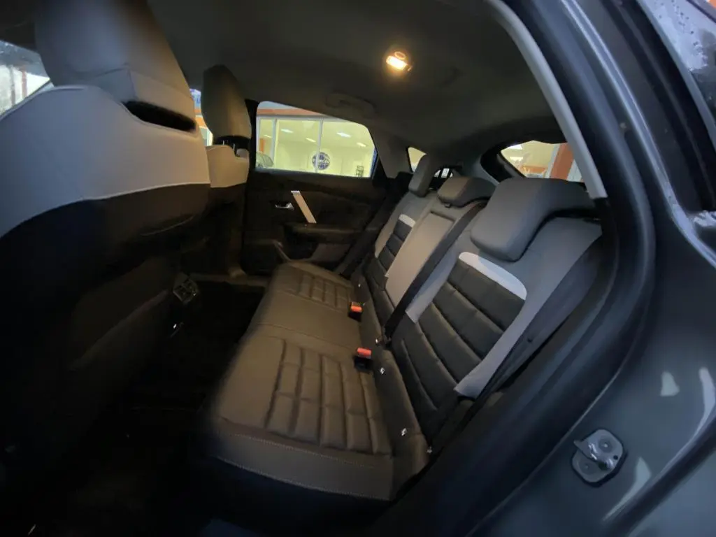 Vue intérieure côté droit des sièges arrière en cuir noir et gris d'une Citroën C4 2025 gris foncé.