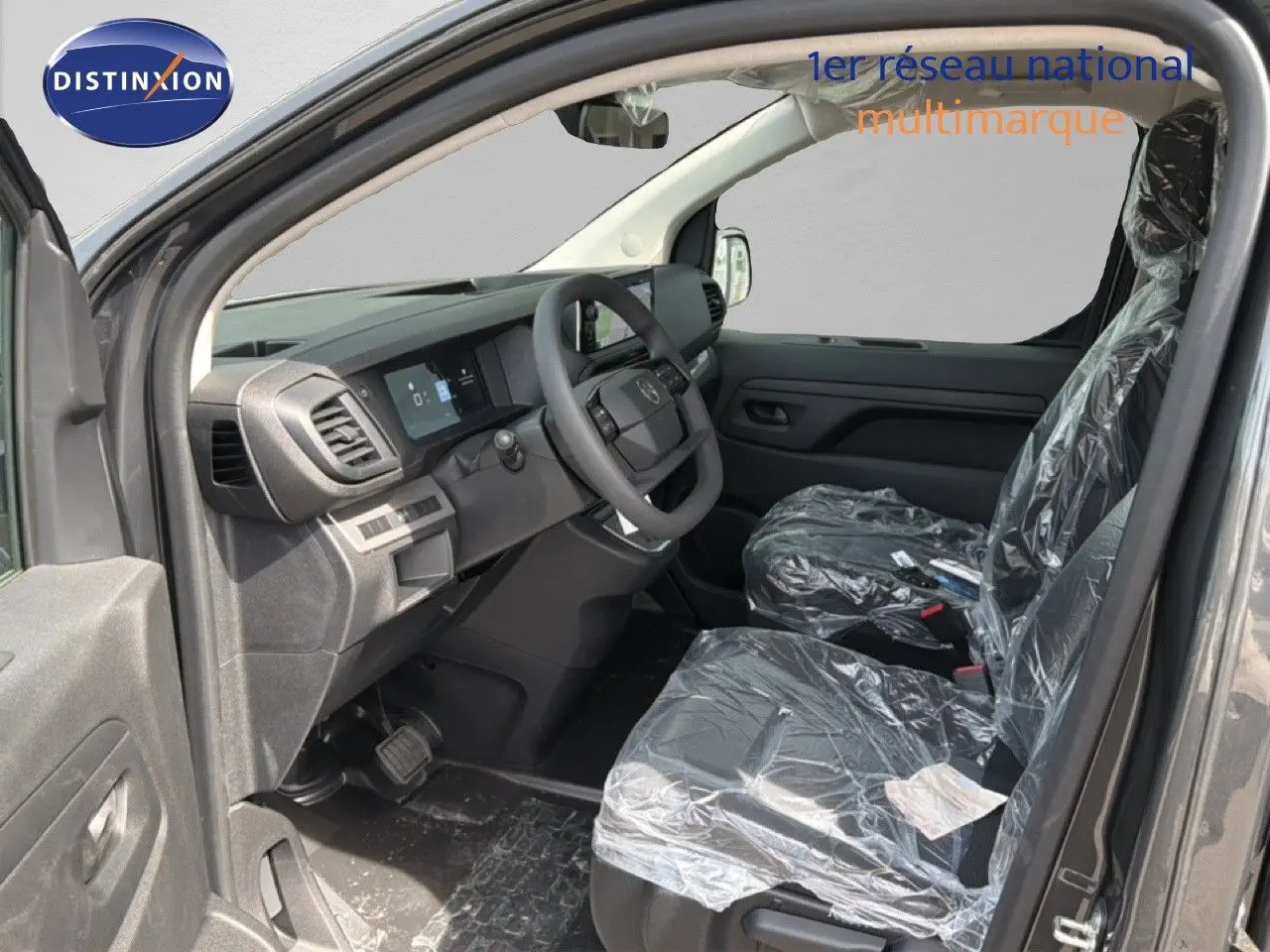 Vue intérieure côté conducteur du Citroën Jumpy cabine approfondie 2026, tableau de bord moderne et sièges tissu gris.