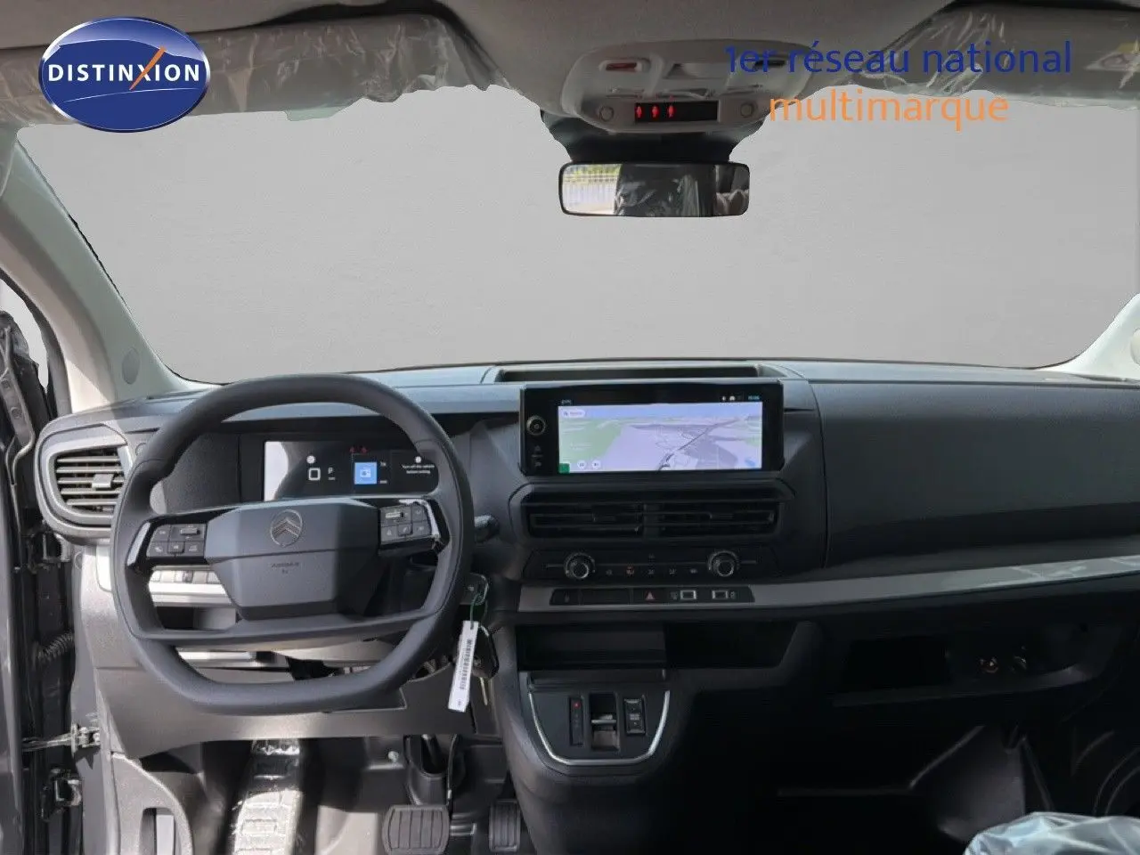 Vue intérieure côté gauche du poste de conduite du Citroën Jumpy cabine approfondie gris titane avec sièges tissu noirs.