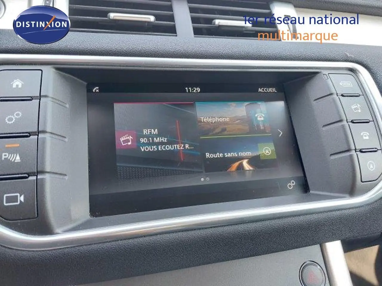 Écran tactile central du Range Rover Evoque blanc 2018 affichant radio et navigation, vue intérieure du tableau de bord.