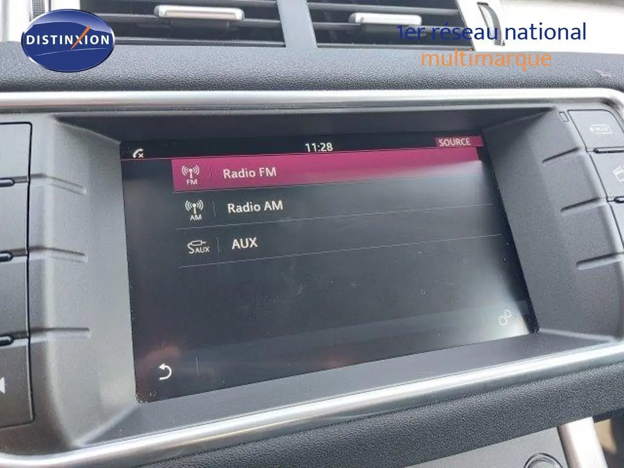 Écran tactile central du Range Rover Evoque 2018 affichant les options Radio FM, AM et AUX dans un intérieur noir.