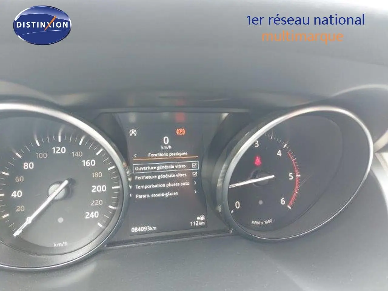 Tableau de bord du Range Rover Evoque blanc 2018, affichant vitesse, compte-tours et menu des fonctions pratiques.