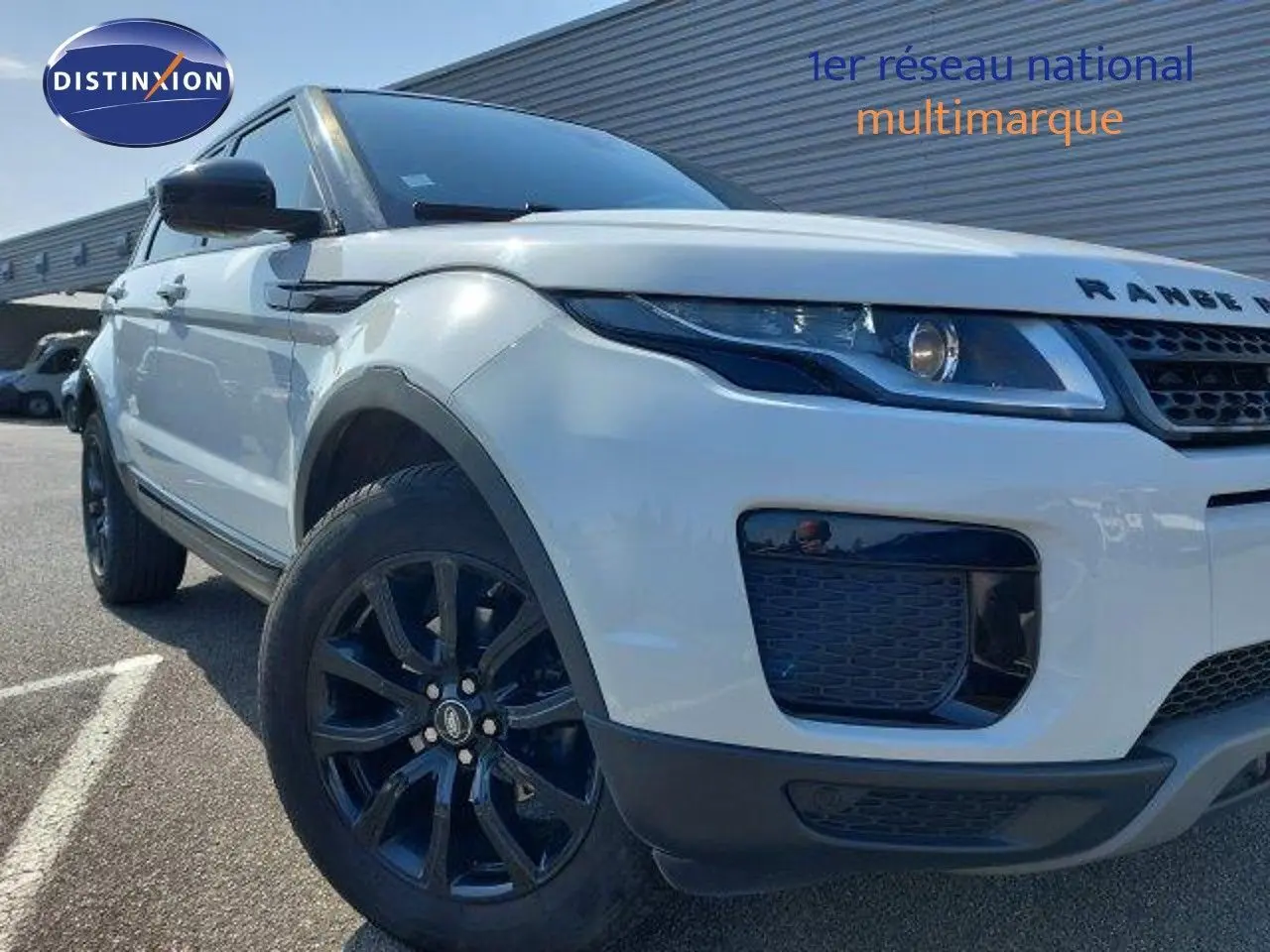 Vue 3/4 avant gauche d'un Range Rover Evoque blanc de 2018 avec jantes noires et calandre distinctive.